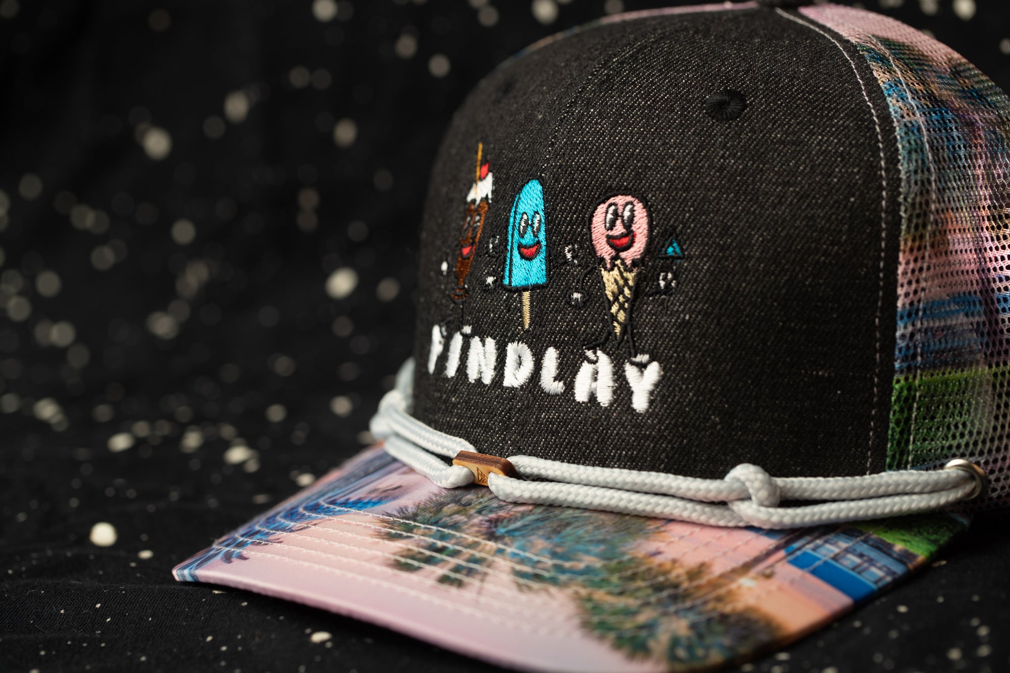 A colorful baseball cap with a printed design and the word "FINDlay" printed on it.