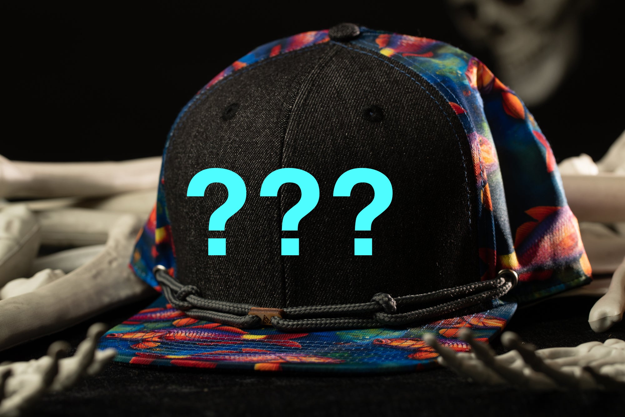 A colorful baseball cap with a question mark symbol on it, surrounded by skeletal bones.