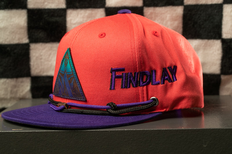 A red baseball cap with a purple brim and a triangular patch on the front, featuring the word "Findlay" in blue letters.