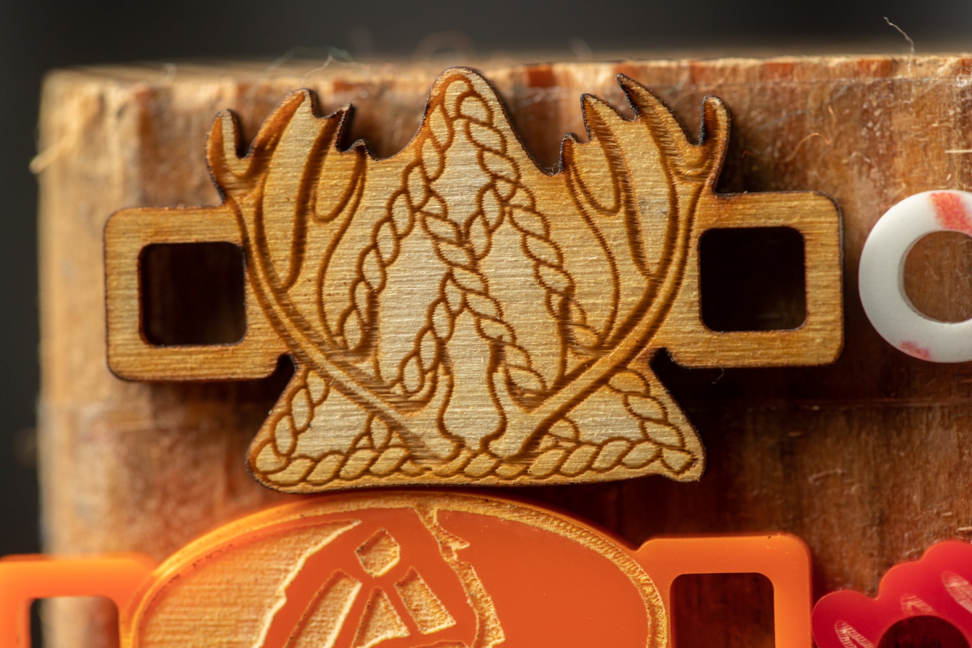 a wooden object with a carved design, including a pair of antlers and a star-like shape.