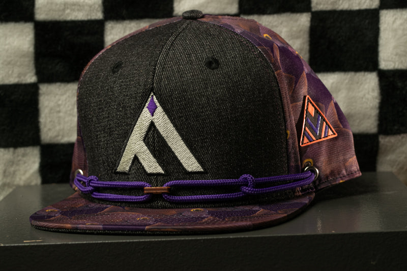 A black baseball cap with a purple and orange patterned design, featuring a white "A" logo on the front.