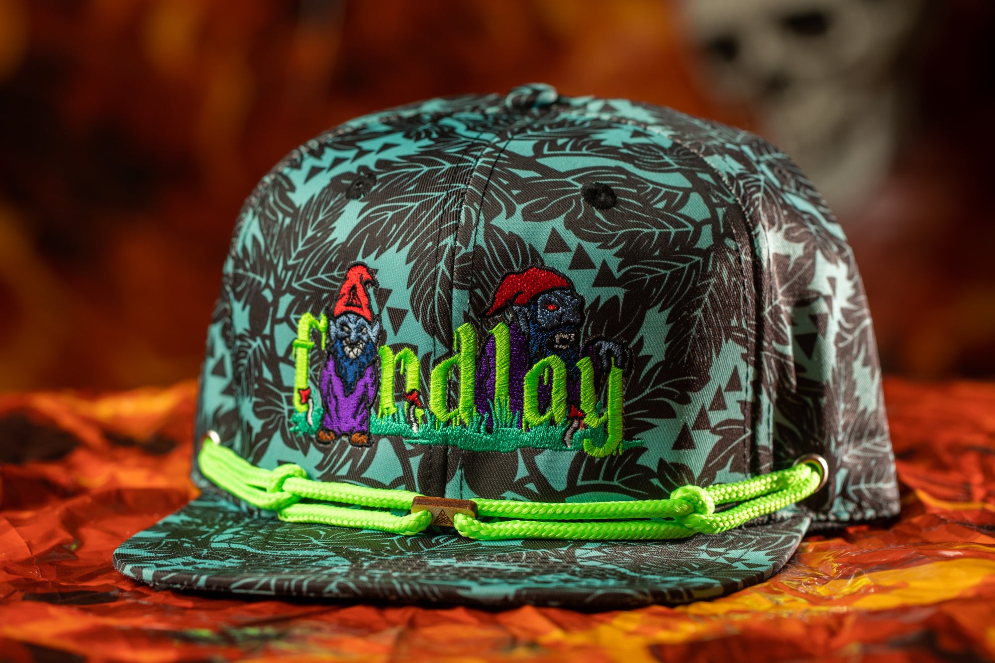A colorful baseball cap with a patterned design and the word "Findlay" printed on it, sitting on a surface with a blurred background.