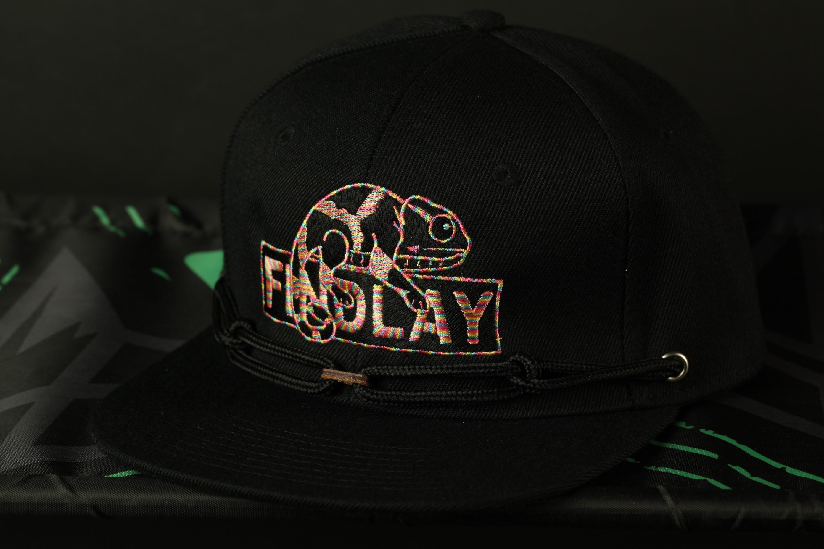 A black baseball cap with a colorful graphic design on the front.