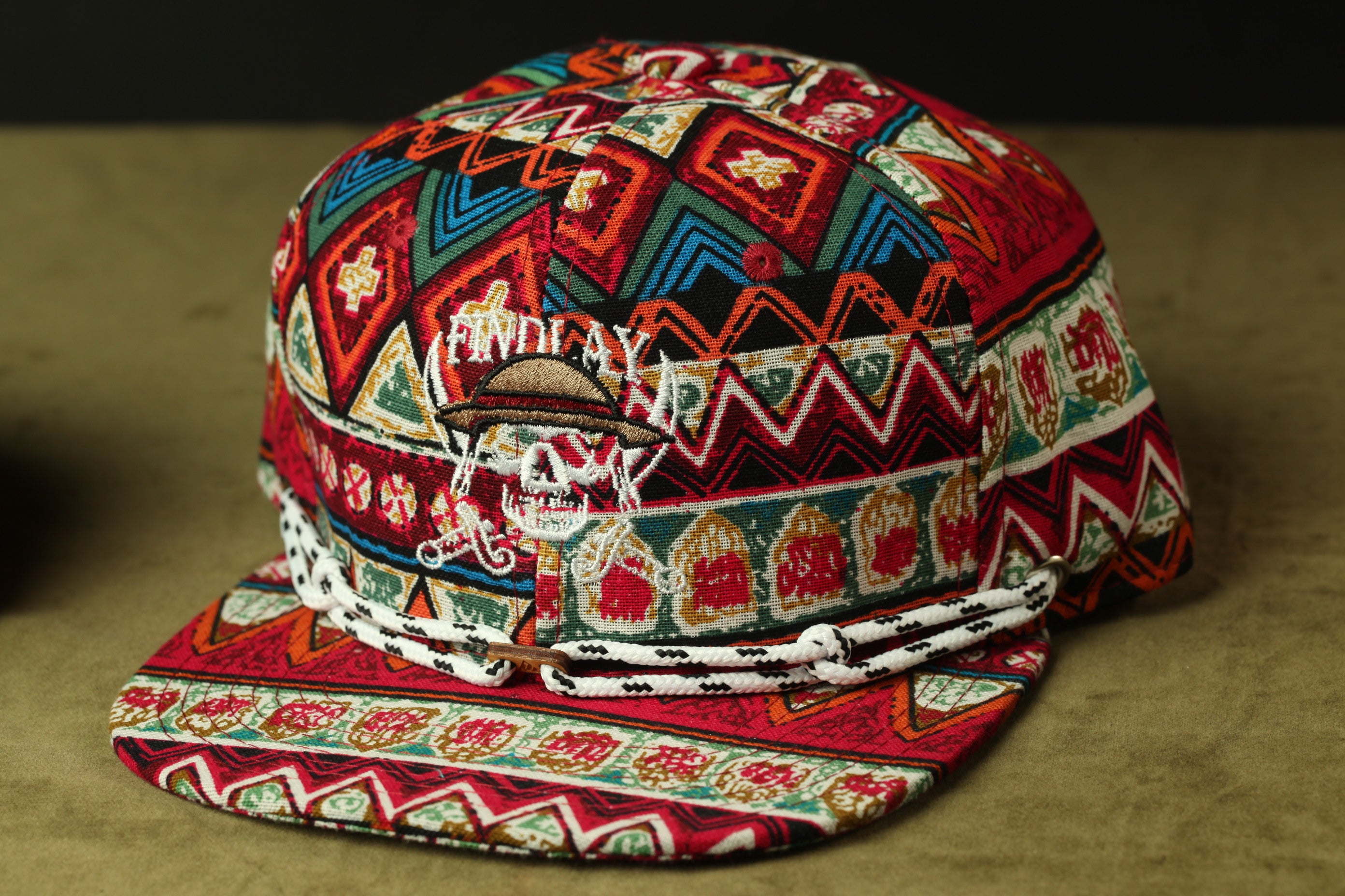 A colorful, patterned baseball cap with a skull design on the front.
