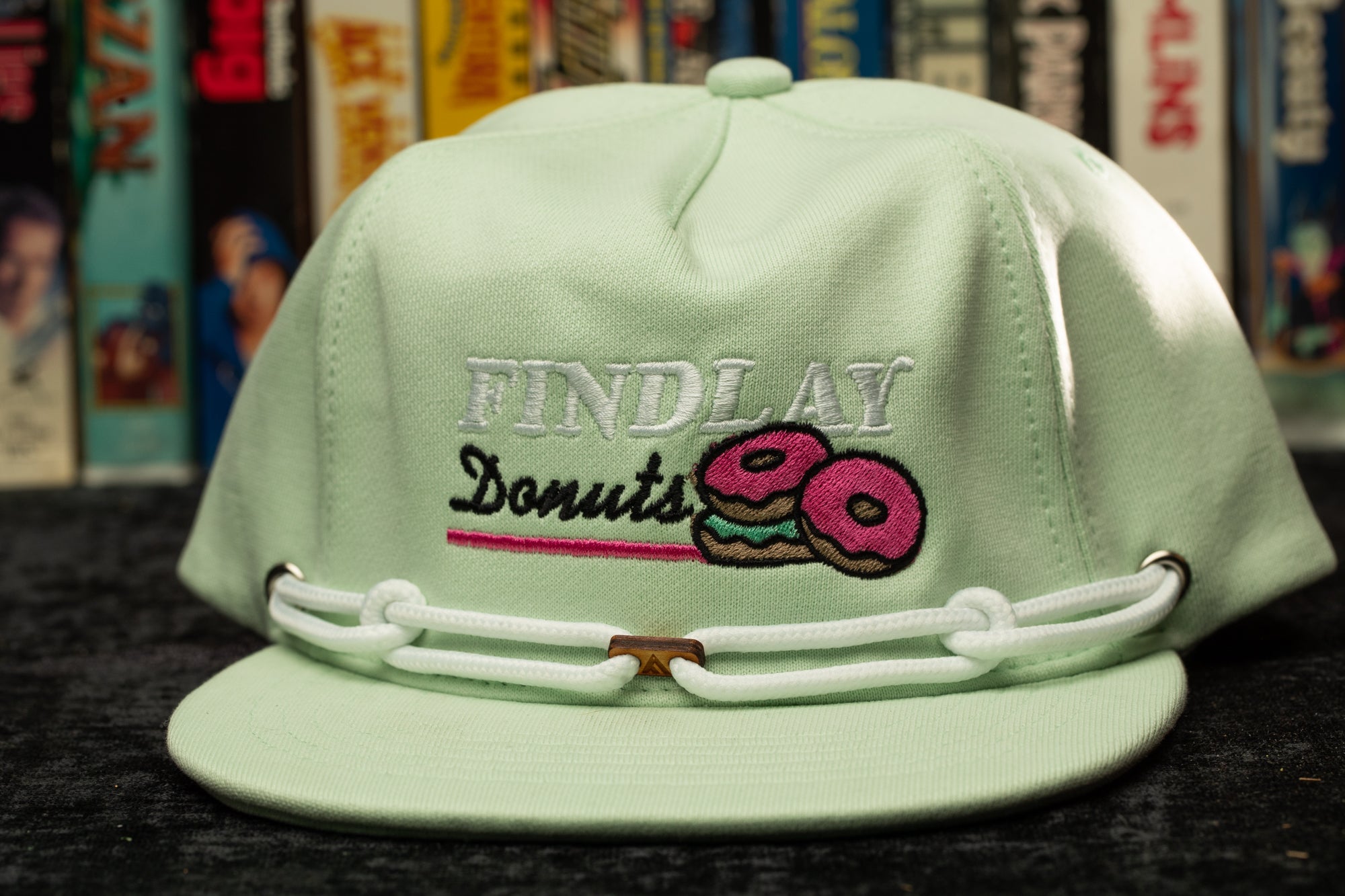 a green hat with a donut embroidered on it