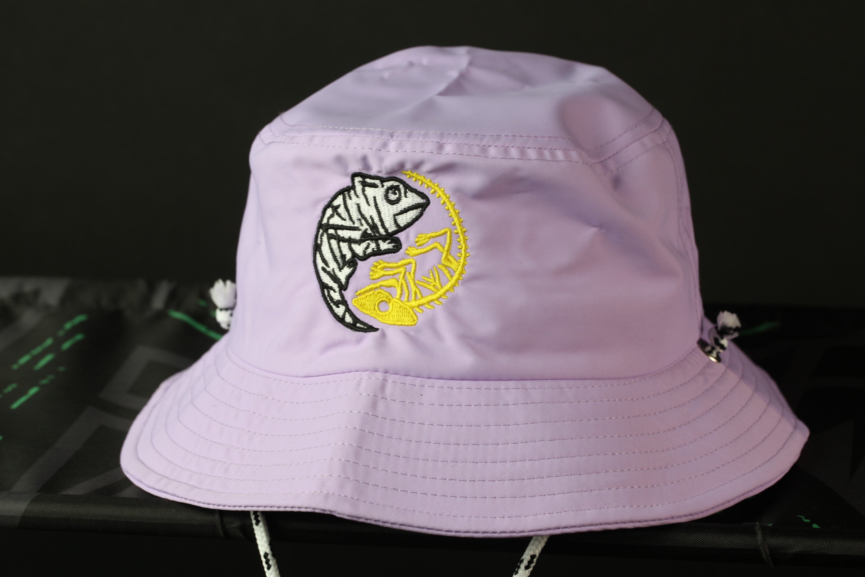 A purple bucket hat with a yellow and black zebra-like design on the front.