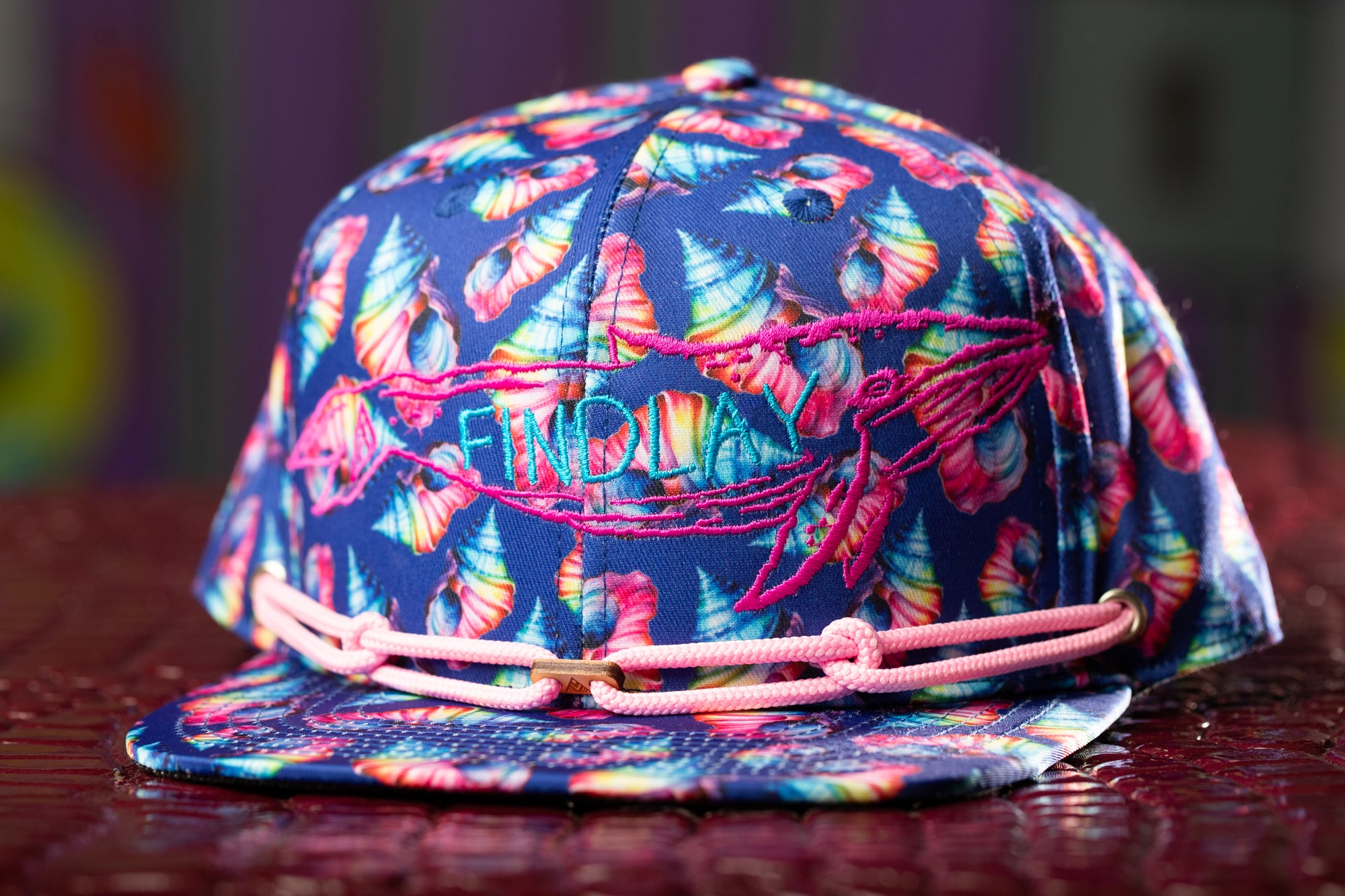 a colorful hat with a pink string around the brim