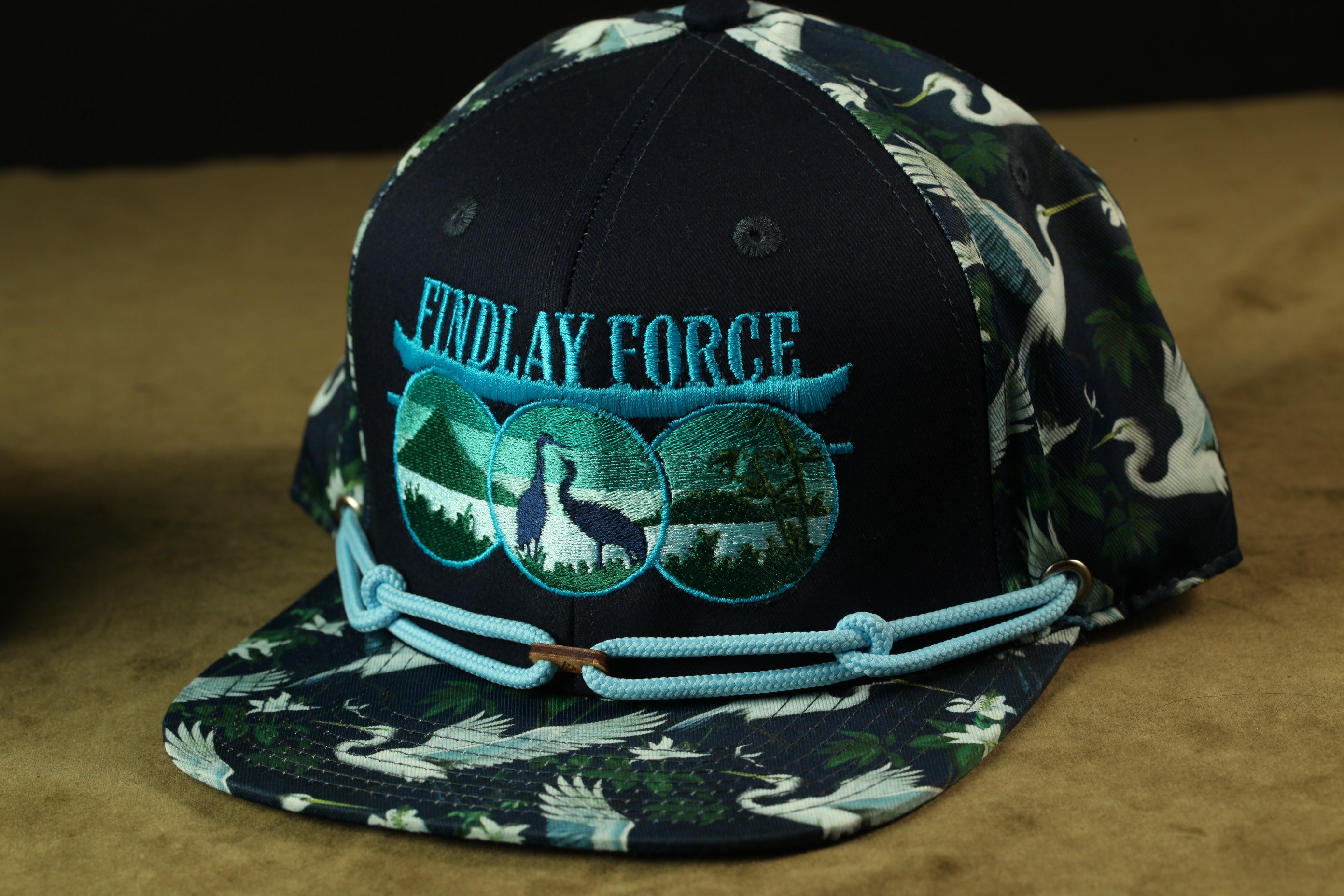 A black baseball cap with a floral pattern and the text "Findlay Force" printed on it.