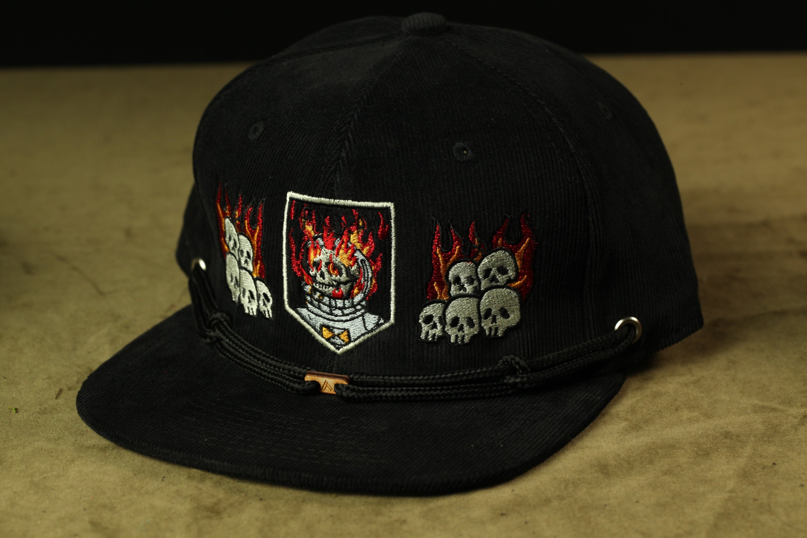 A black baseball cap with a design featuring a skull and flames on the front.