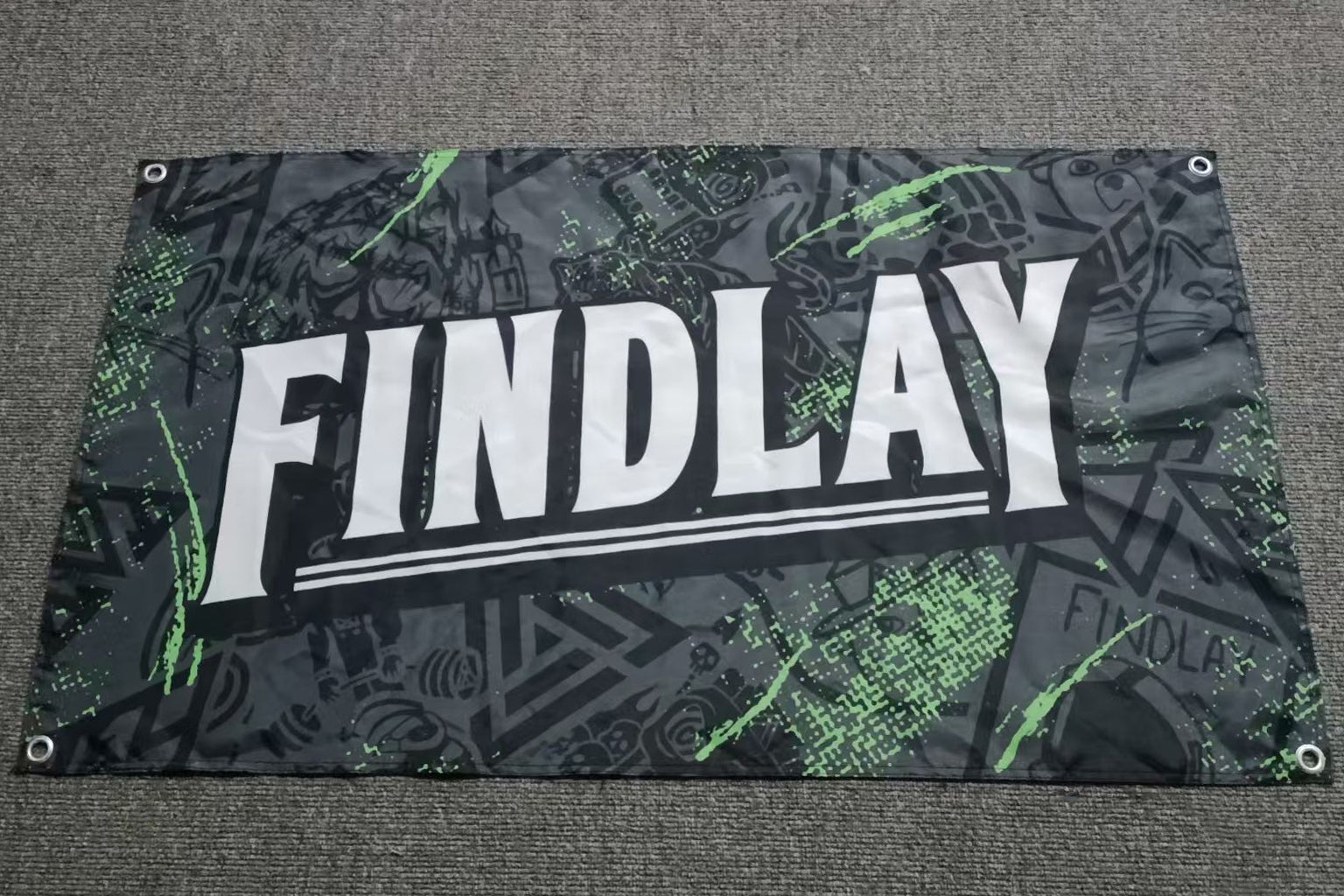 a banner with the word "FINDLAY" prominently displayed in large white letters against a black and green background with various abstract and geometric patterns.
