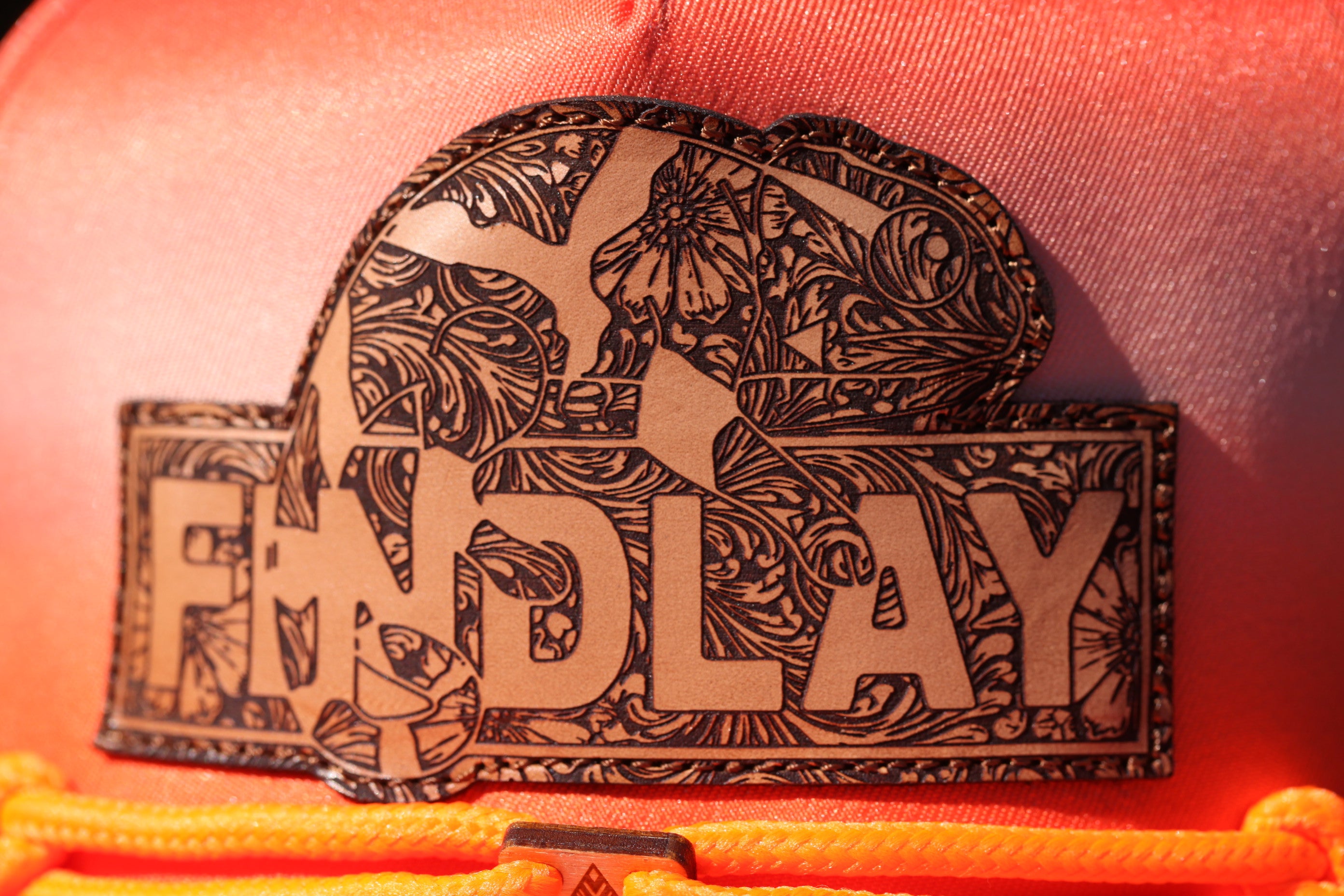 a close-up of a decorative label or patch with a floral pattern and the word "FIND LAY" printed on it.