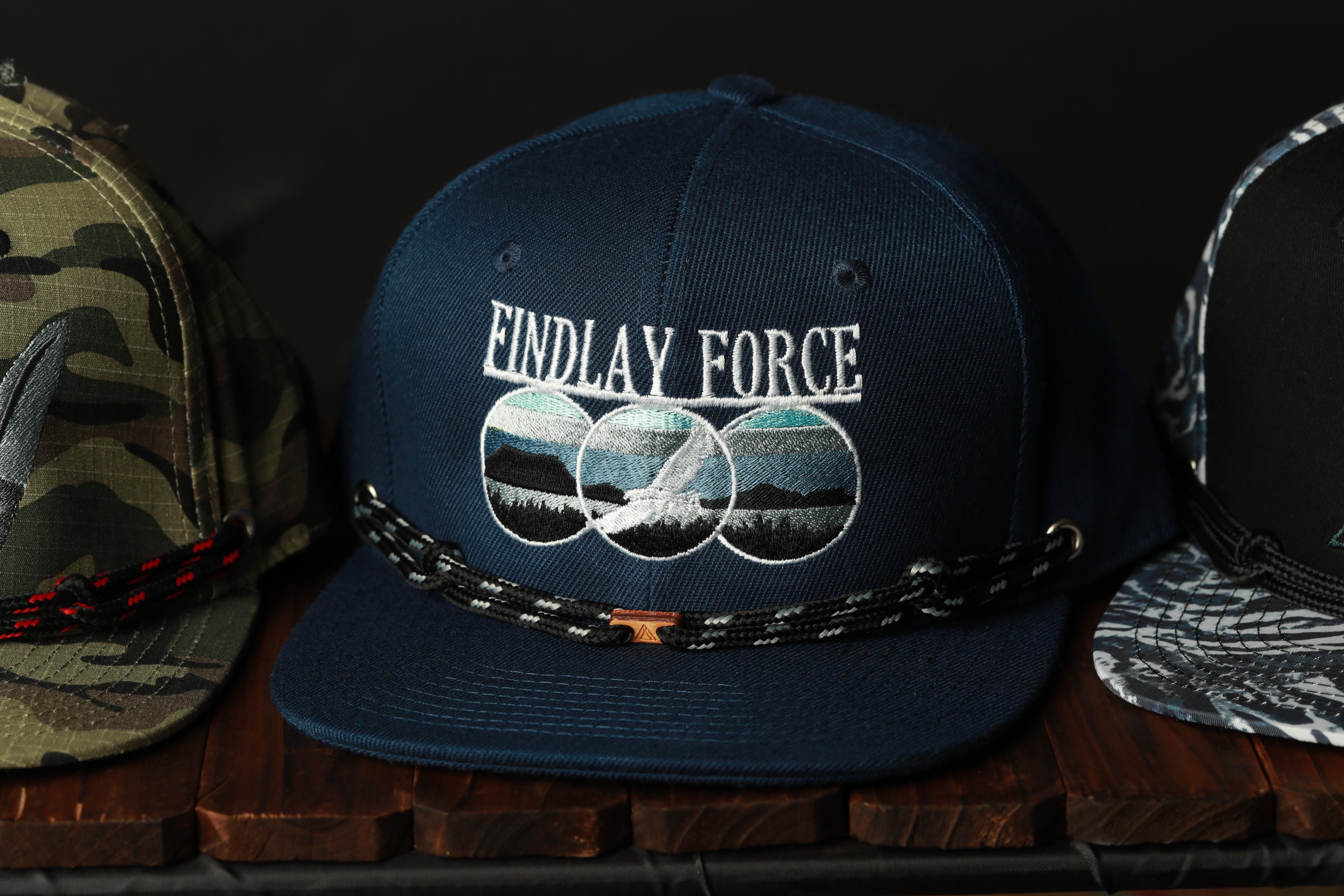 A navy blue baseball cap with the text "ENDLAY FORCE" printed on it, along with a graphic of a mountain range.