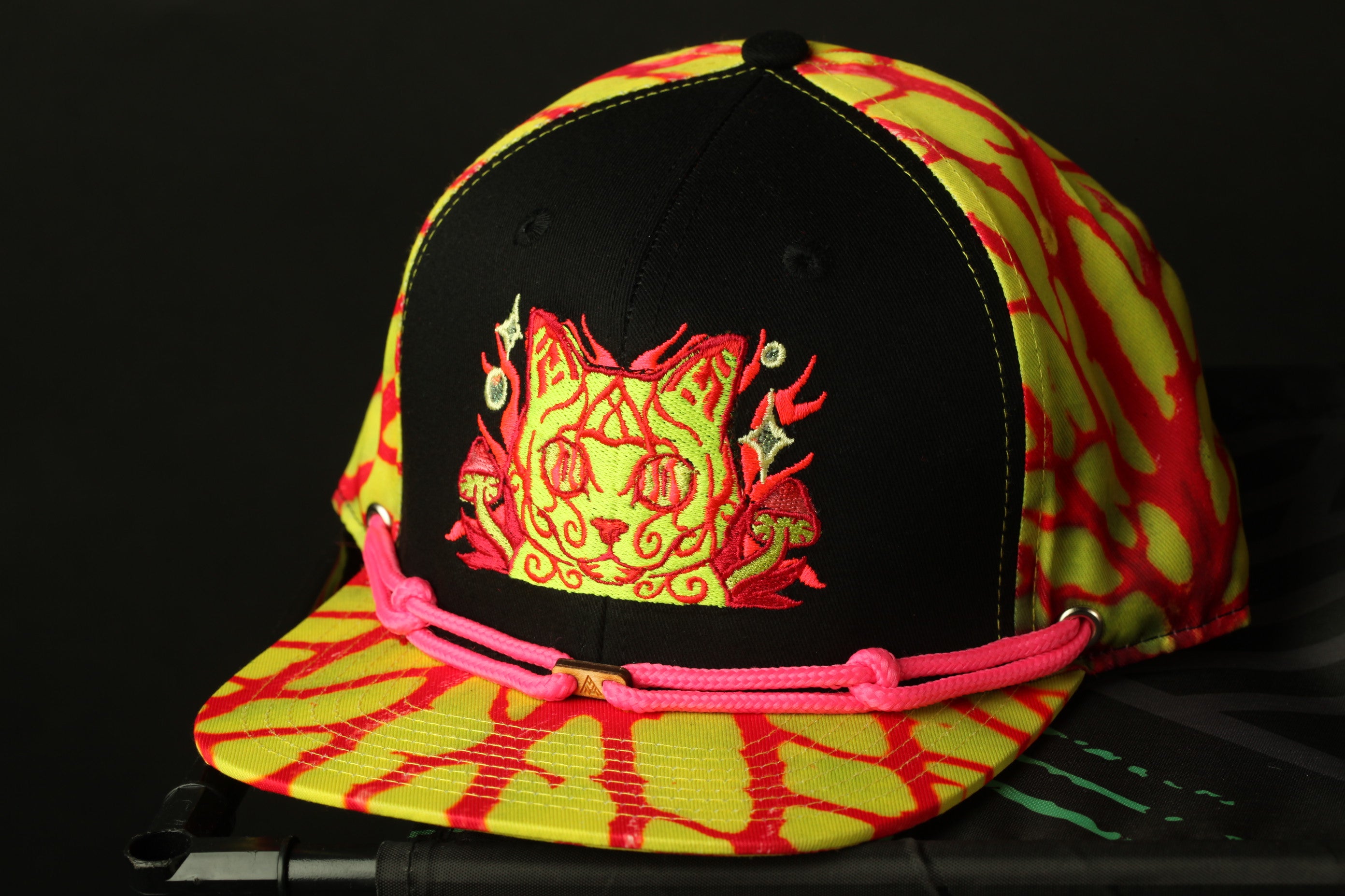 A colorful baseball cap with a black brim and a vibrant yellow and red patterned fabric.