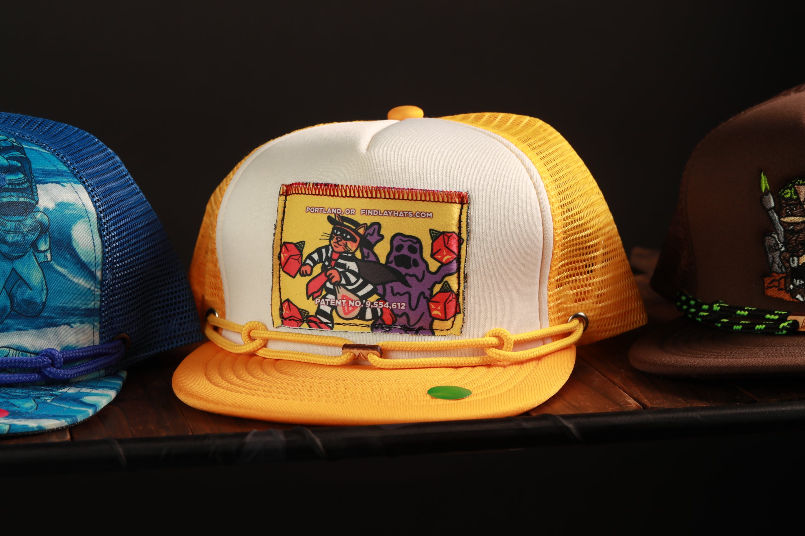 A collection of colorful baseball caps on display, including a yellow and white cap with a cartoon character design.
