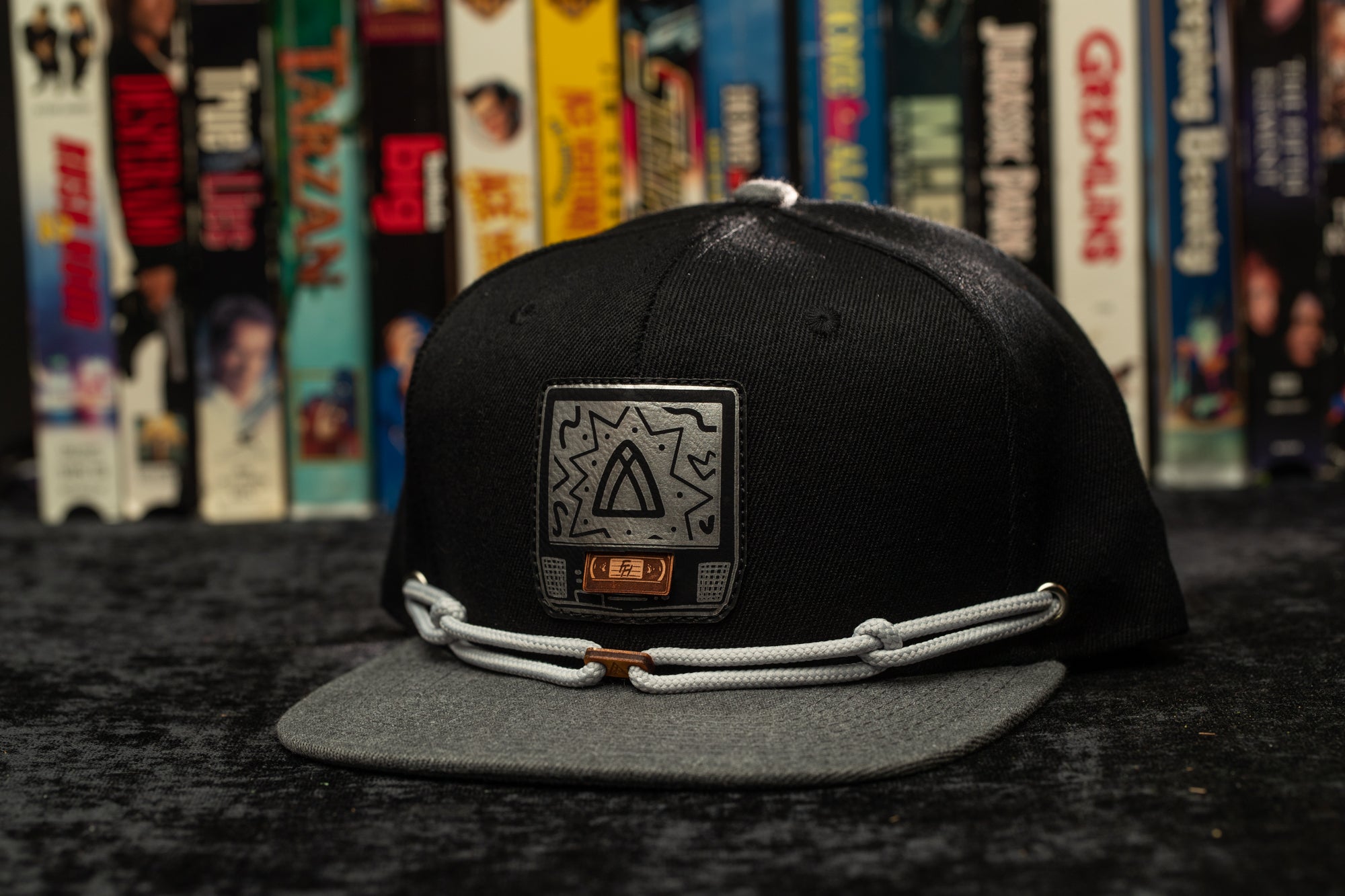a black and grey hat with a picture of a triangle on it