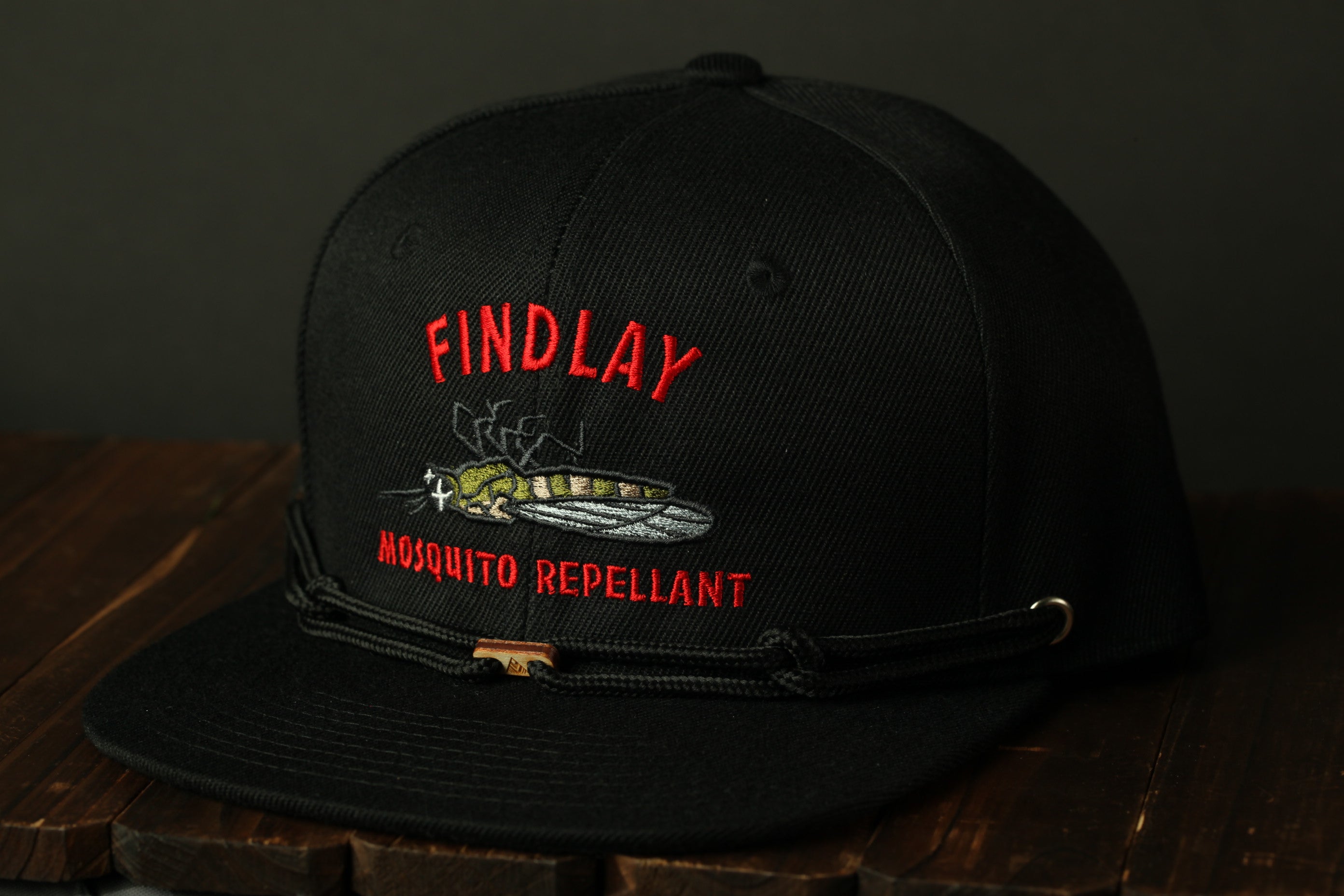 A black baseball cap with a red and white logo on it, which says "FIND LAY" and "MOSQUITO REpellANT".