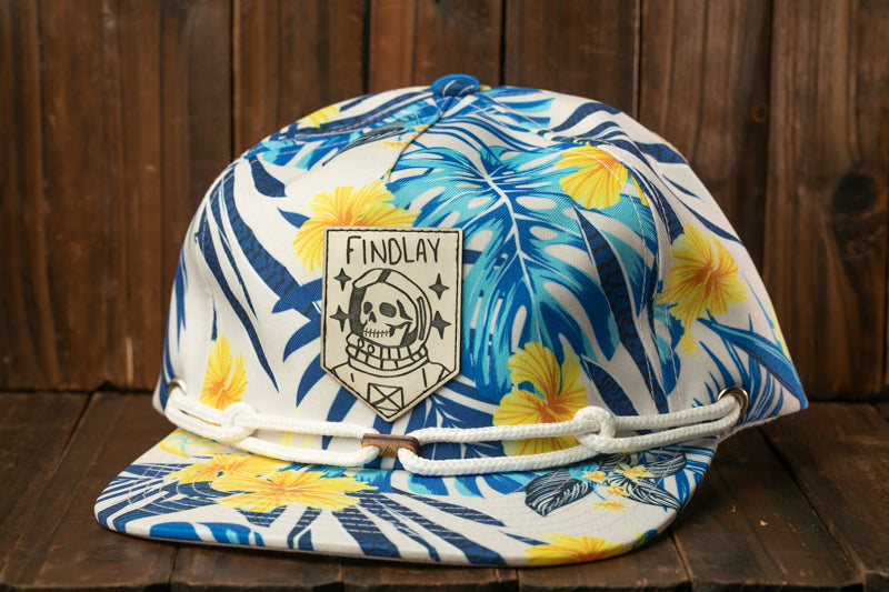 A colorful floral baseball cap with a skull and crossbones design, featuring the text "Findlay" on the front.