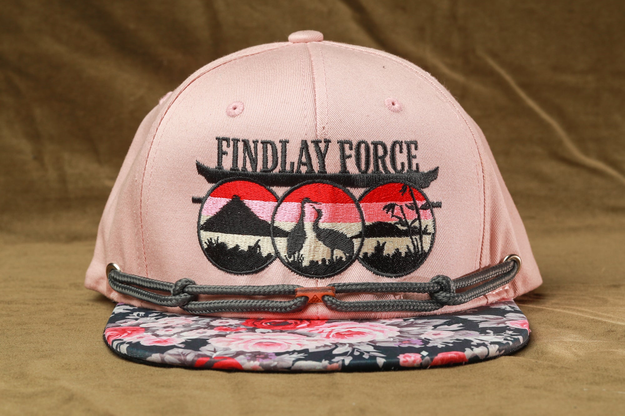 A pink baseball cap with a floral pattern and the text "FINDLAY FORCE" printed on it.
