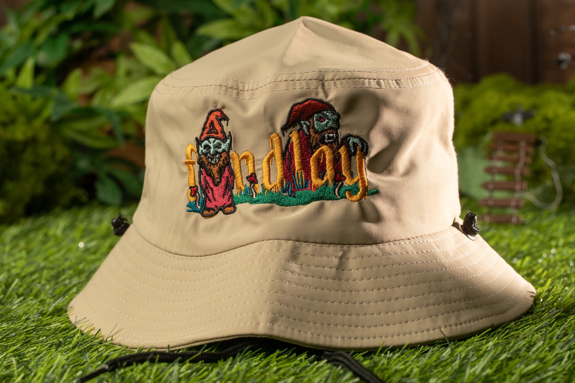 A beige bucket hat with a colorful embroidered design on the front, featuring two cartoon-like characters.