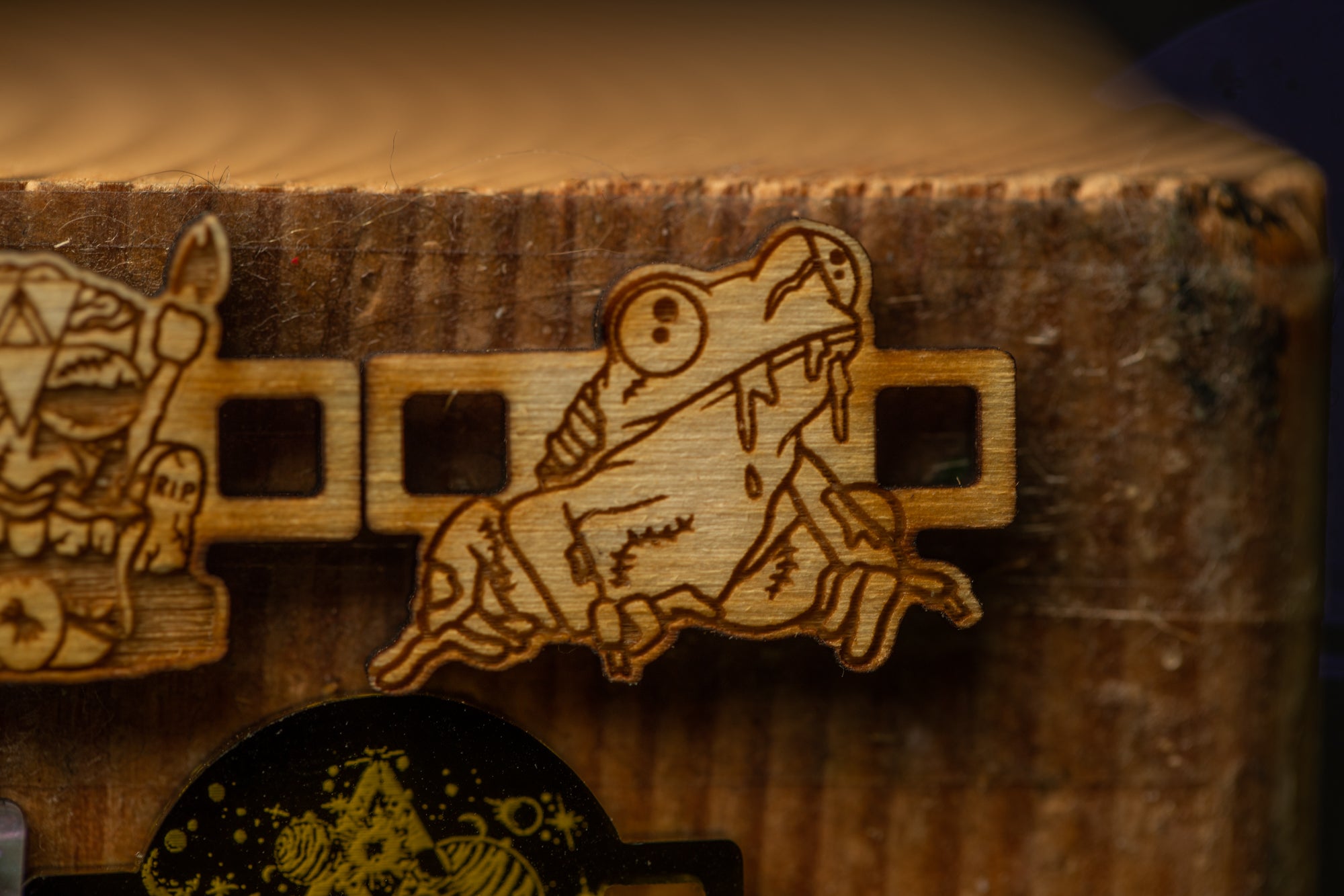 a wooden frog-shaped object with a carved design, placed on a wooden surface.