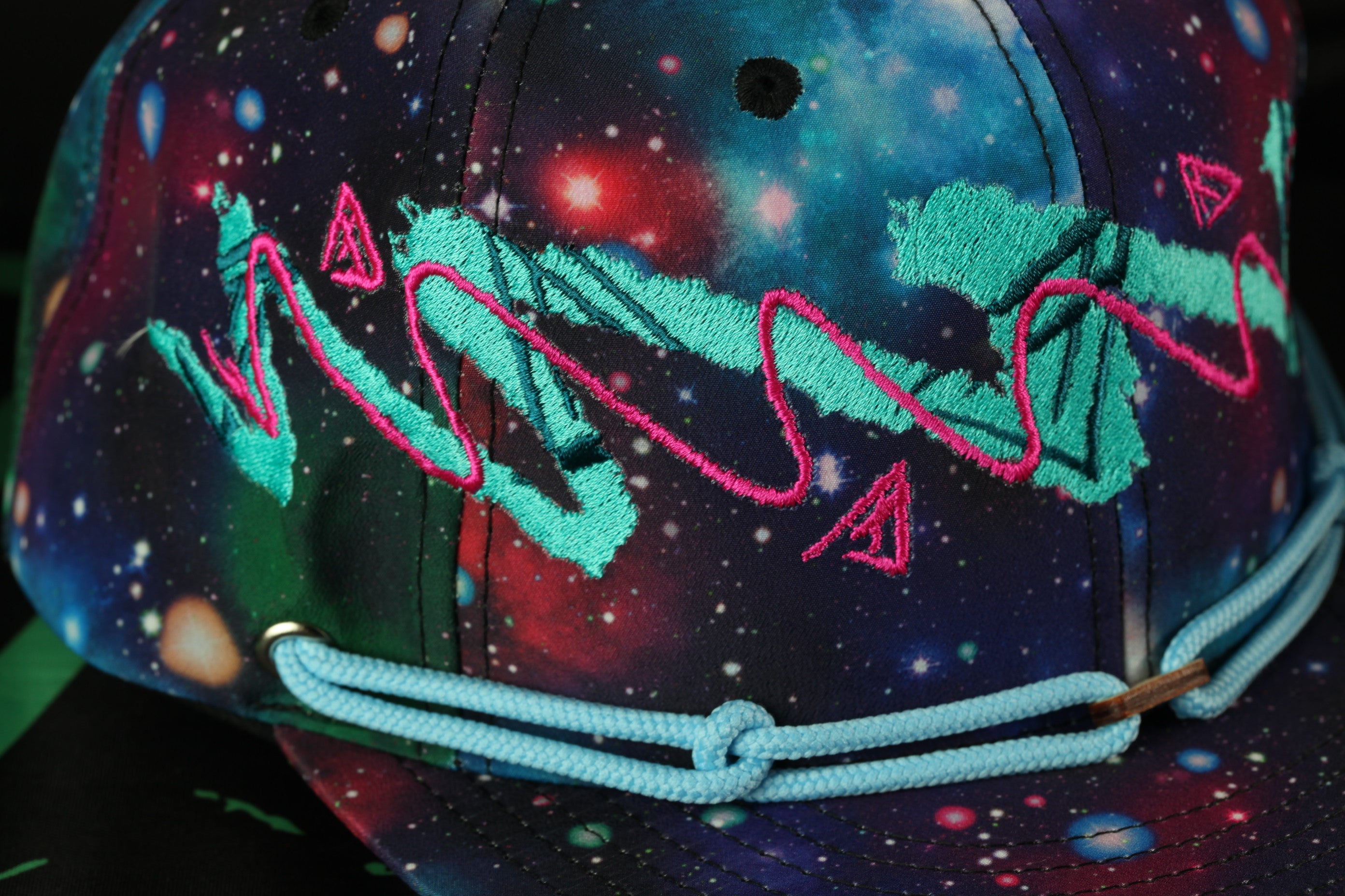 A colorful, patterned baseball cap with a galaxy-themed design.