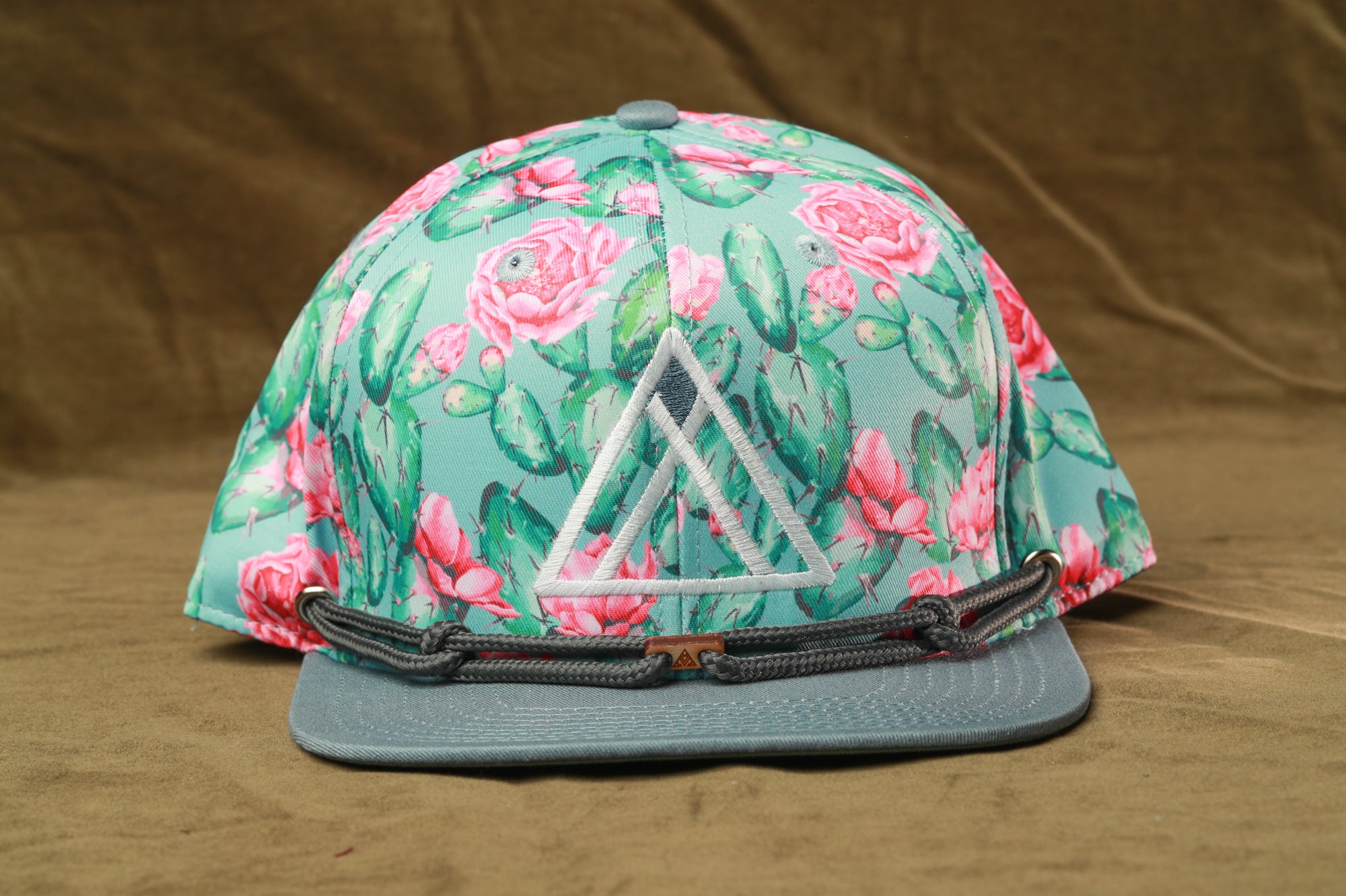 A colorful floral print baseball cap with a triangular logo on the front.