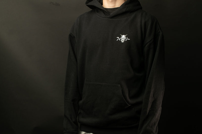 A person wearing a black hoodie with a white logo on the front.