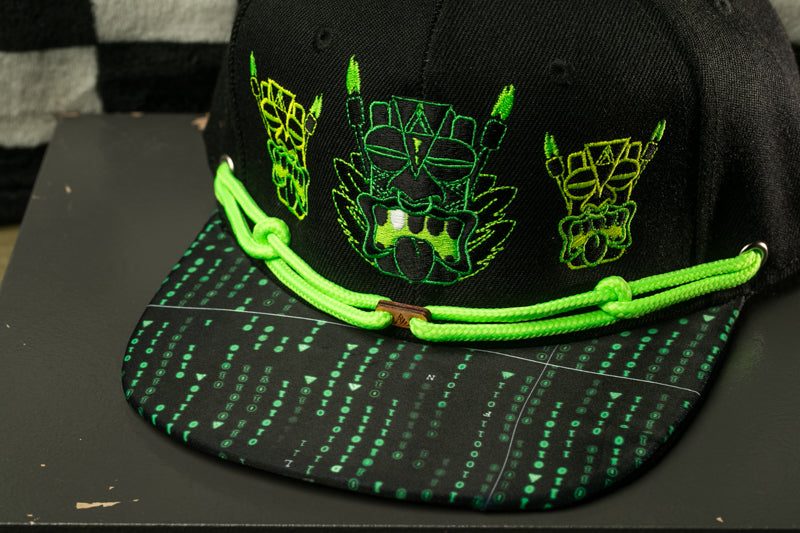 A black baseball cap with green and yellow designs, including a skull and crossbones motif, and a neon green strap.