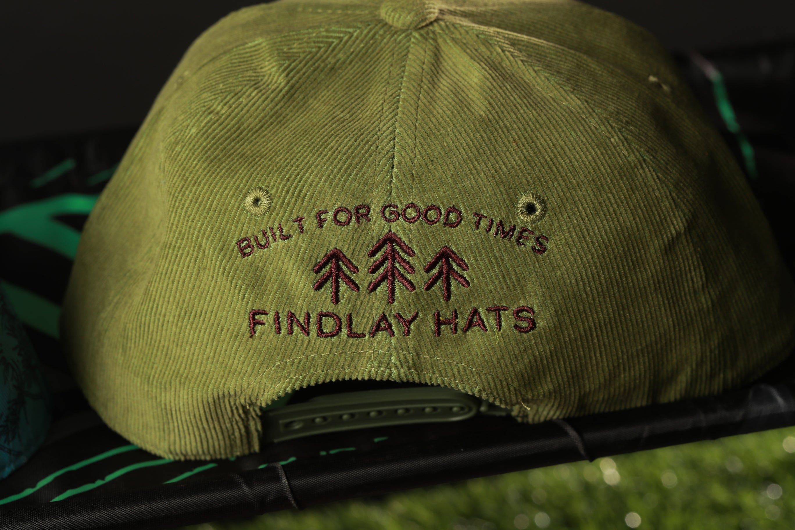 a green baseball cap with embroidered text on it.