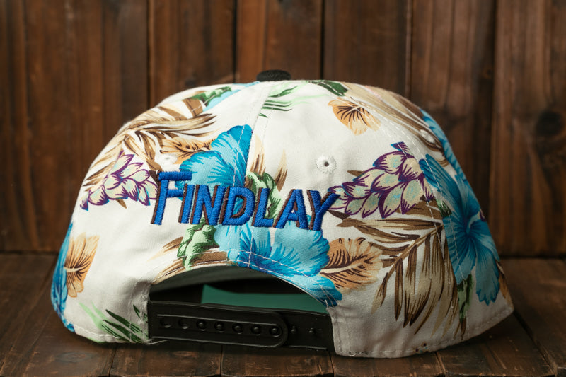 A white baseball cap with a floral print pattern and the word "FINDLAY" embroidered on it.