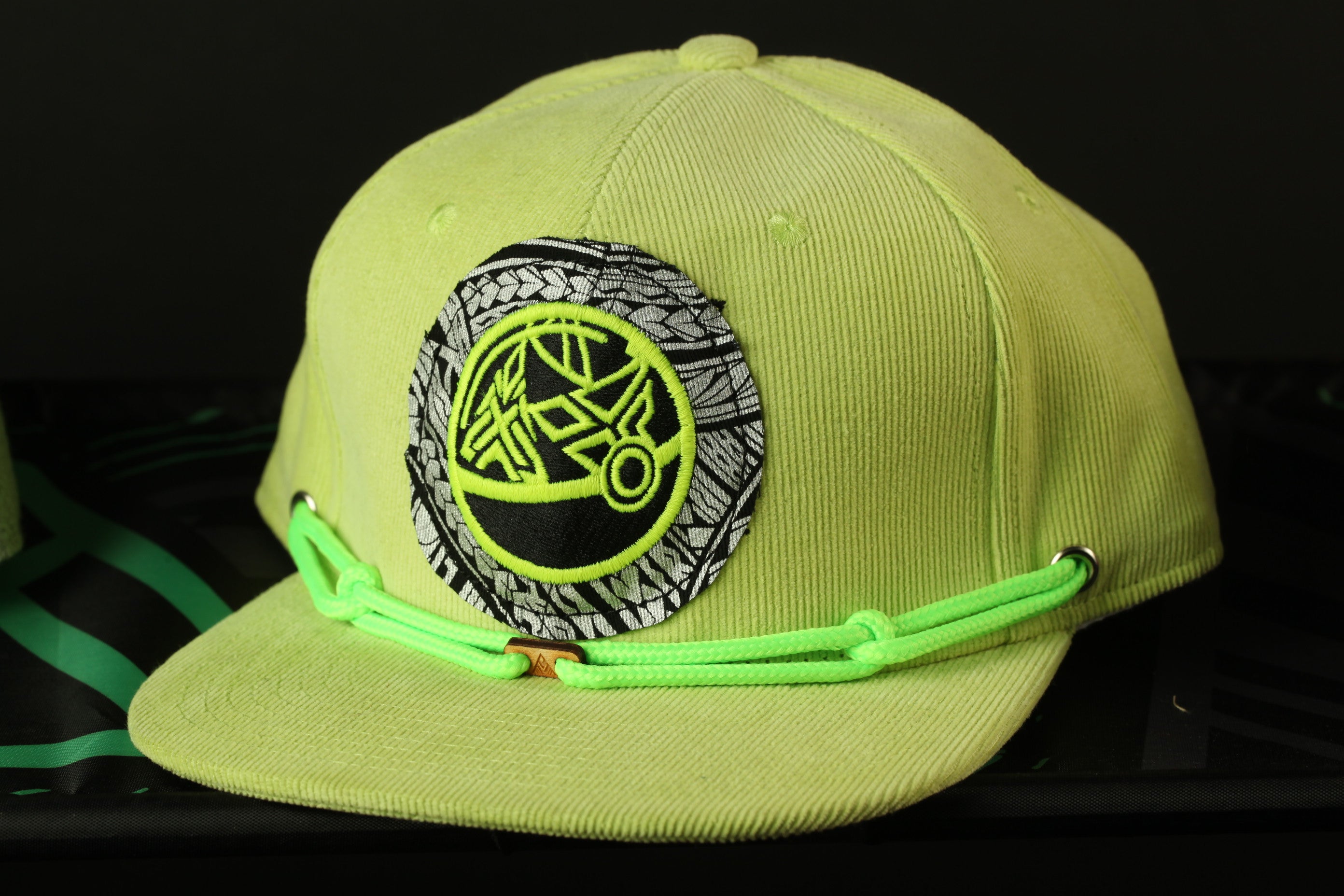 A bright yellow baseball cap with a black and white graphic patch on the front.