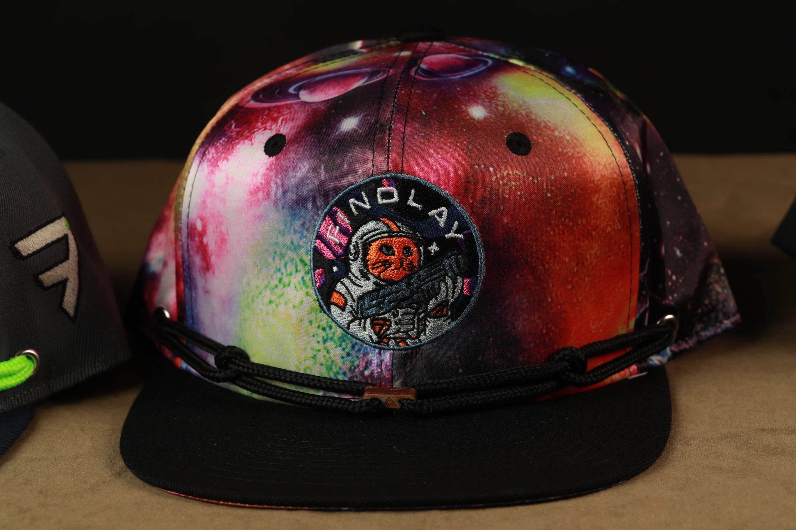 A colorful, space-themed baseball cap with a circular patch featuring an astronaut and the text "INNO'LAY".