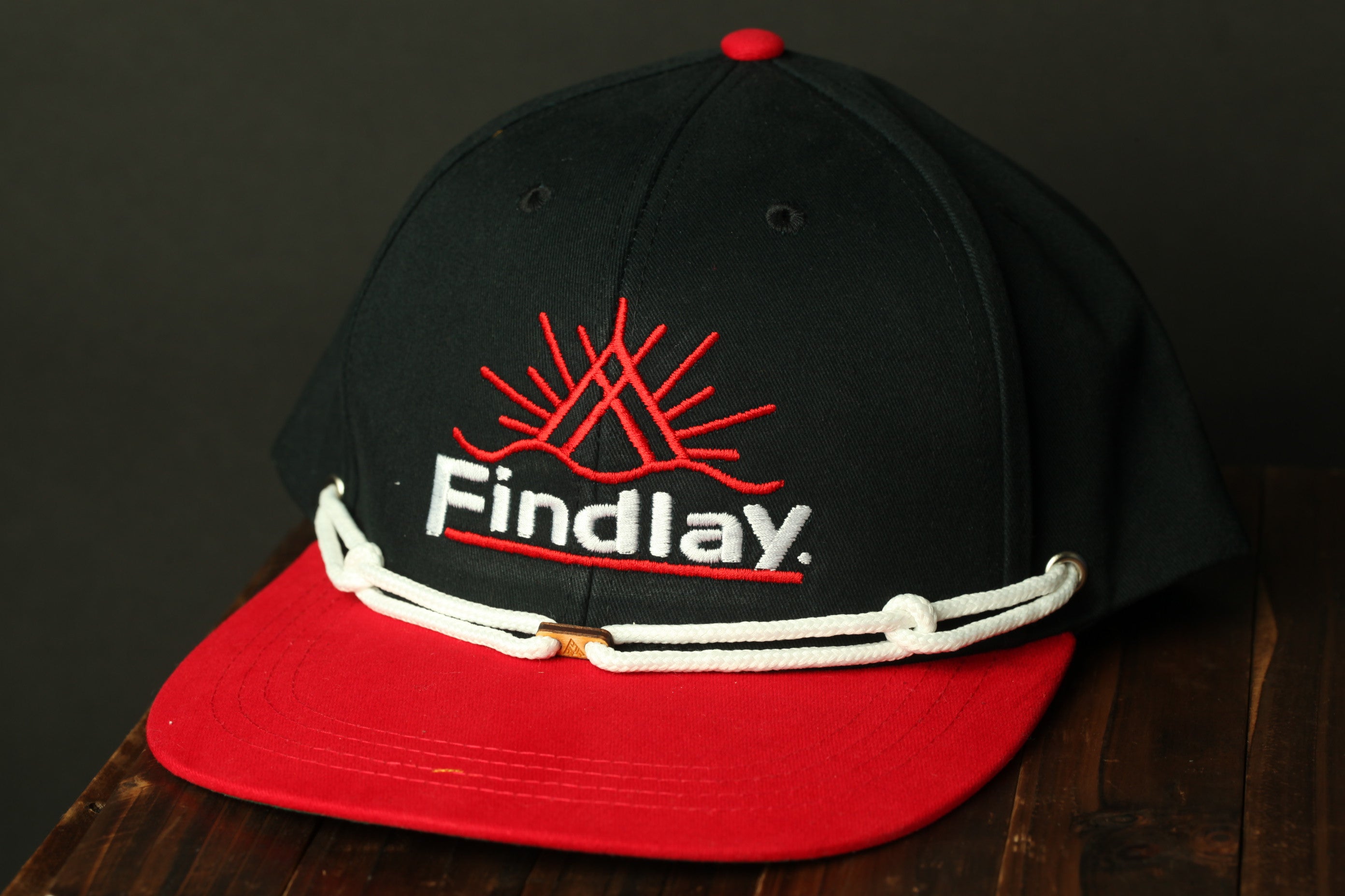 A black baseball cap with a red brim and white stitching, featuring the text "Findlay" on the front.
