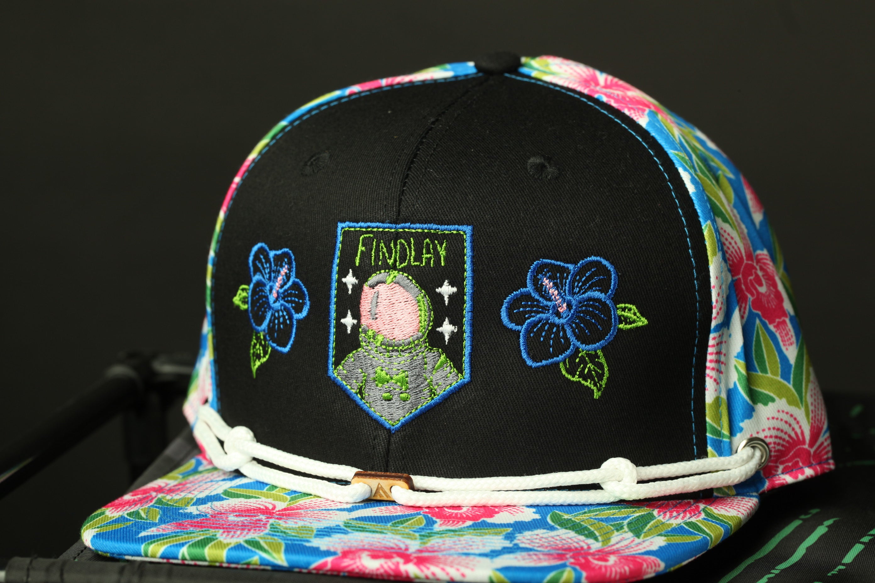 A colorful baseball cap with floral patterns and a patch featuring a character.