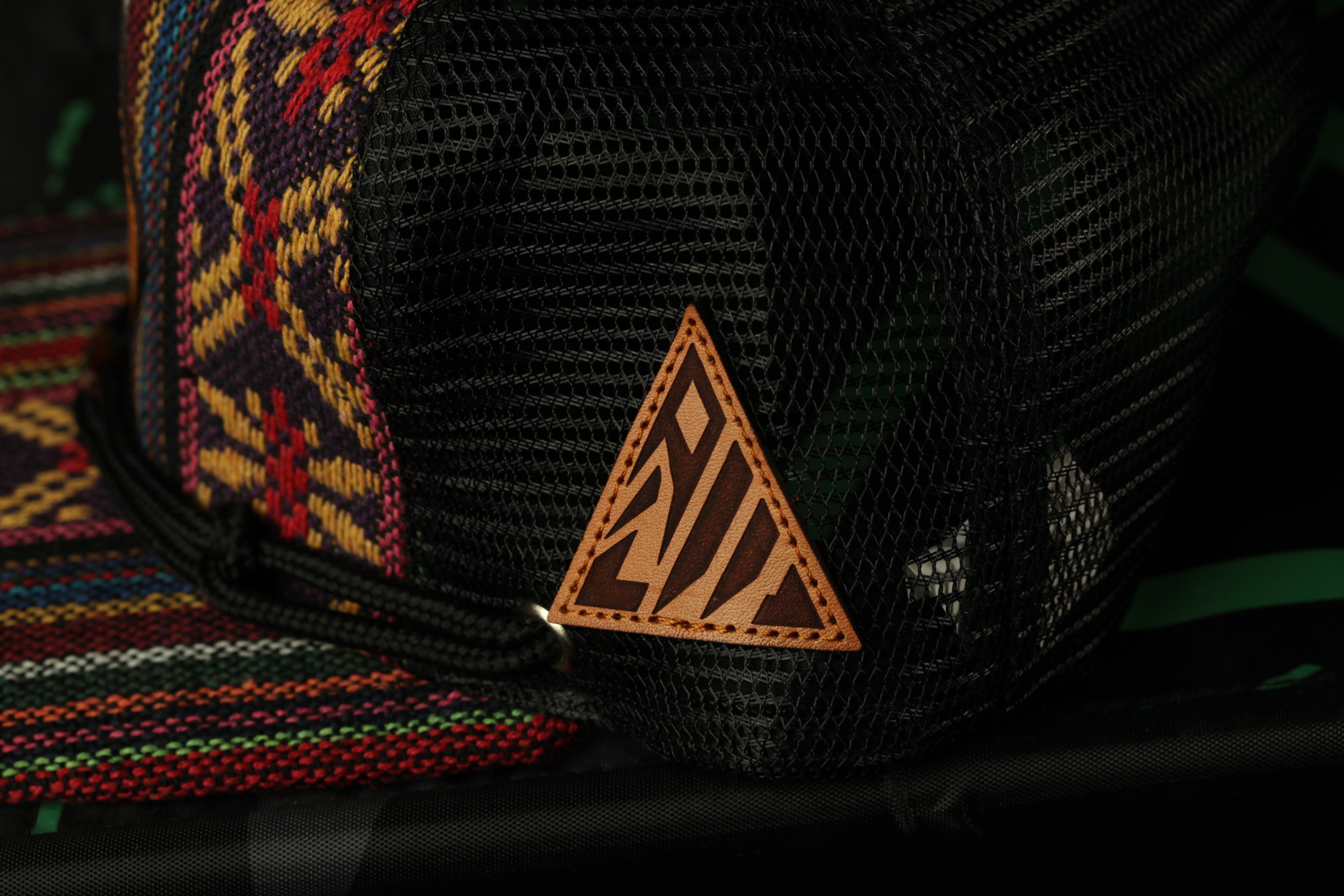 A close-up view of a black mesh bag with a triangular logo on it.