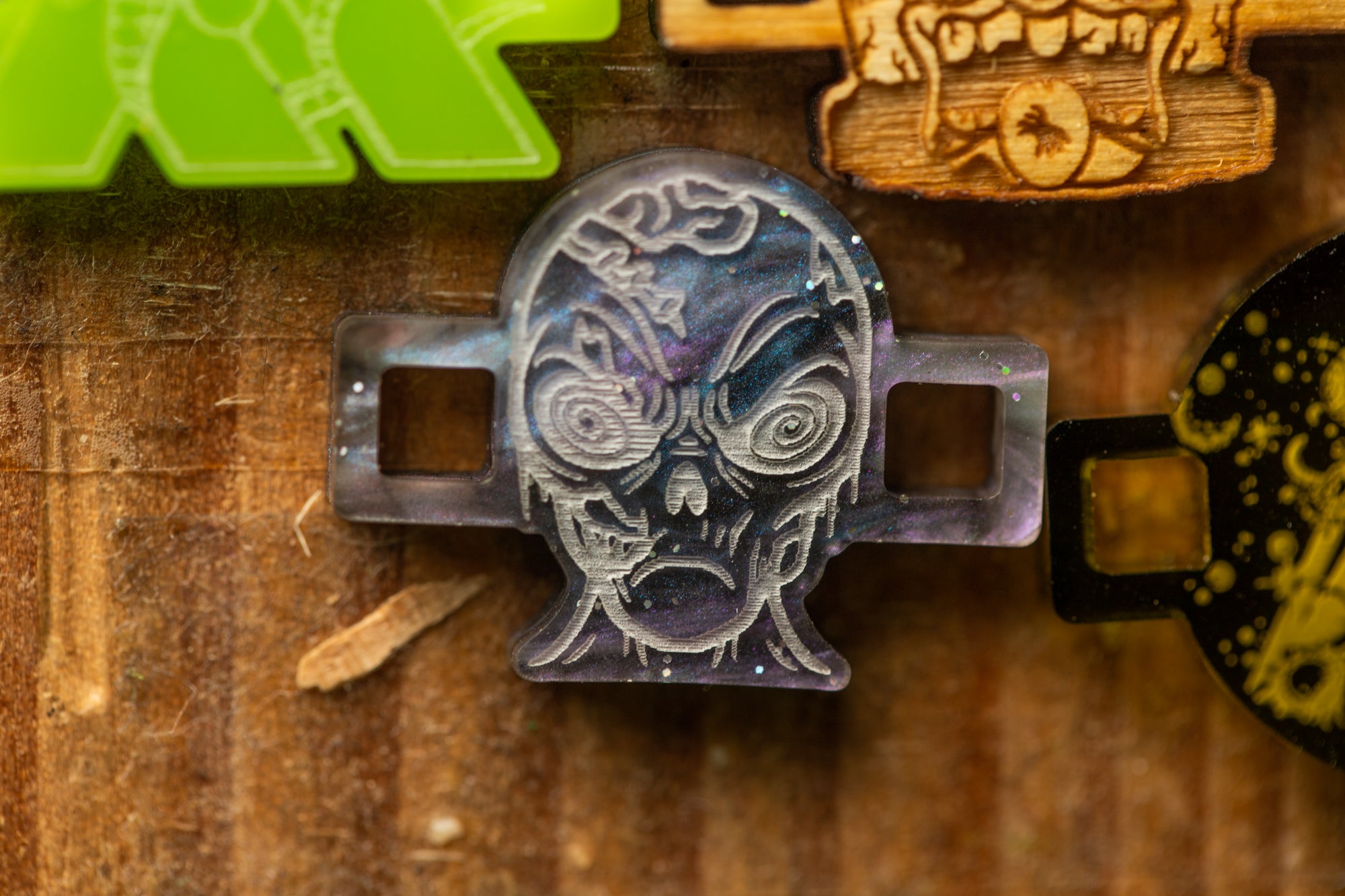 a close-up view of a skull-shaped object with a carved face, set against a wooden background.