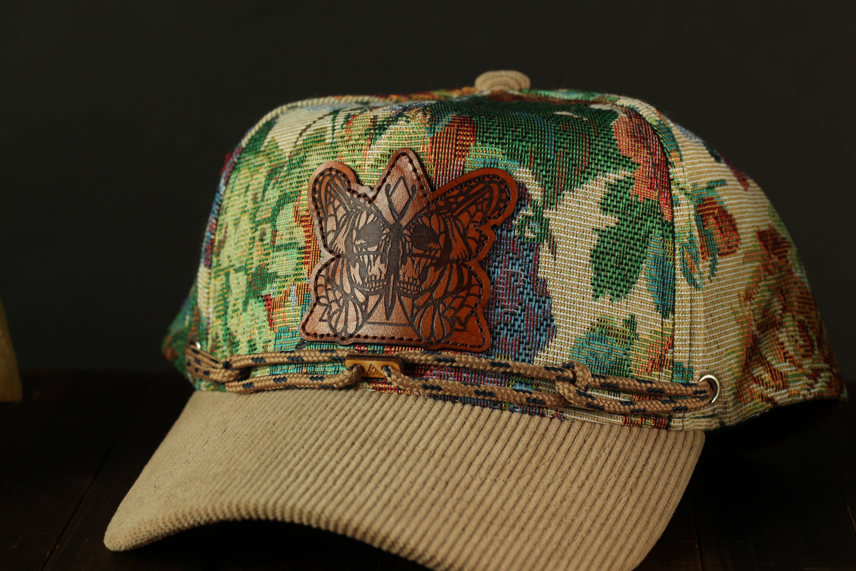 A colorful, patterned baseball cap with a butterfly design on the front.