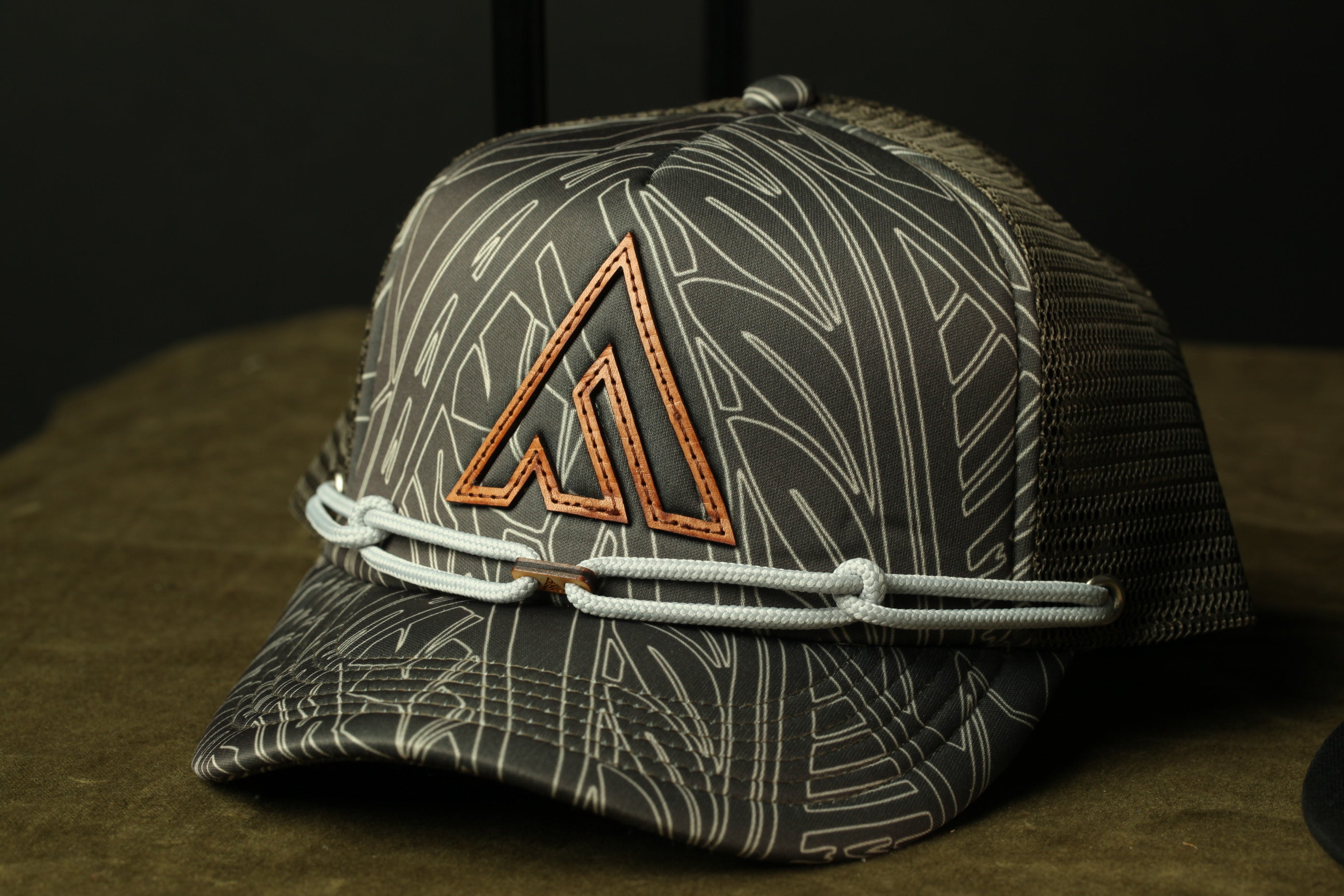 A gray and white patterned baseball cap with a distinctive orange triangle logo on the front.