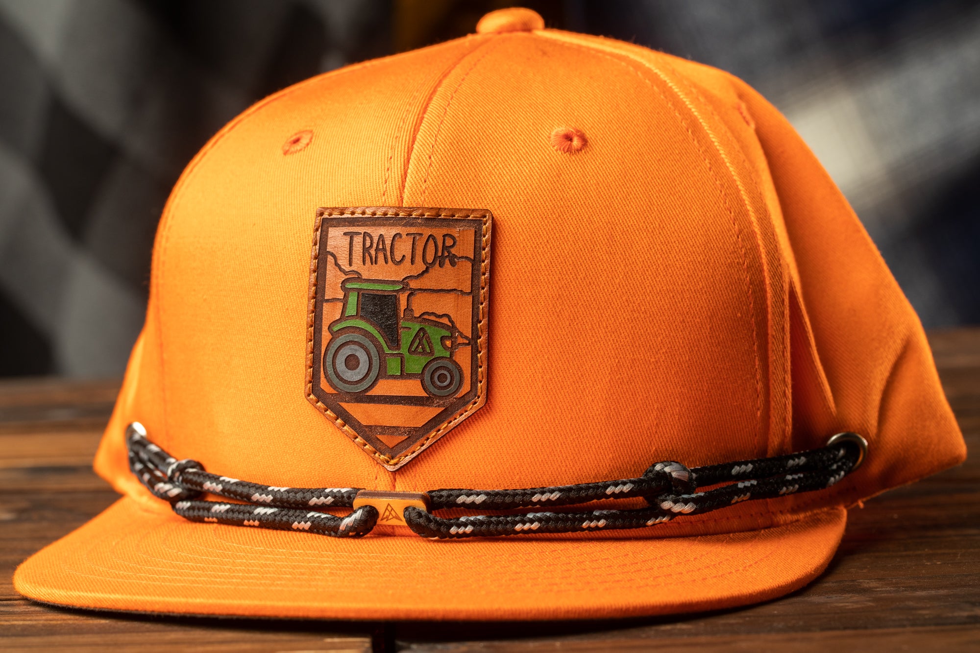 An orange baseball cap with a tractor patch on it.