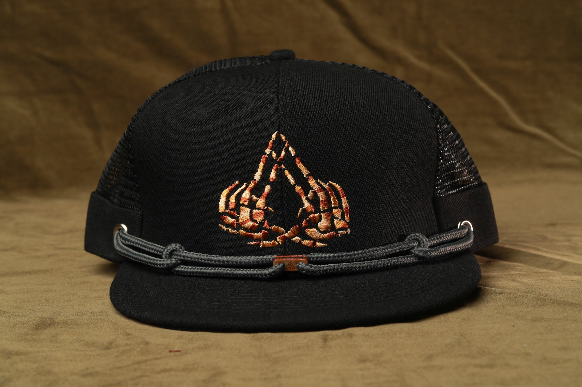 A black baseball cap with a unique skull-like design on the front.