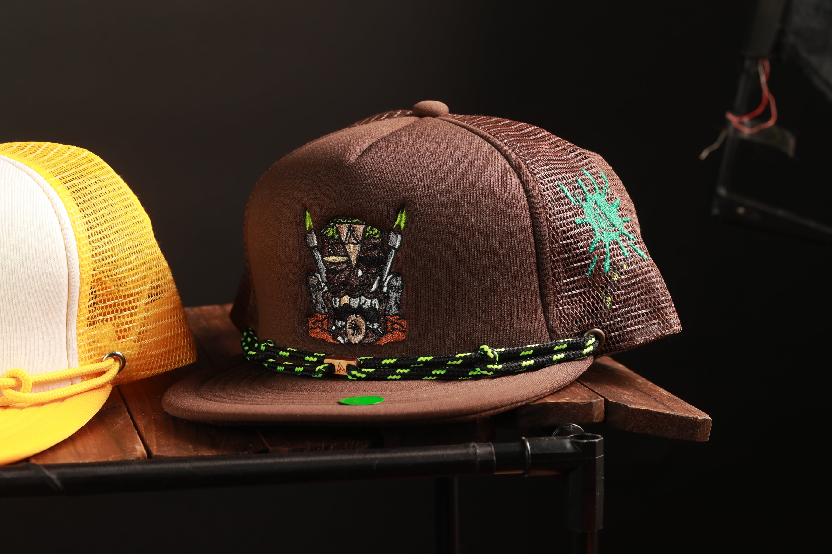a brown baseball cap with a unique design, placed on a wooden surface.