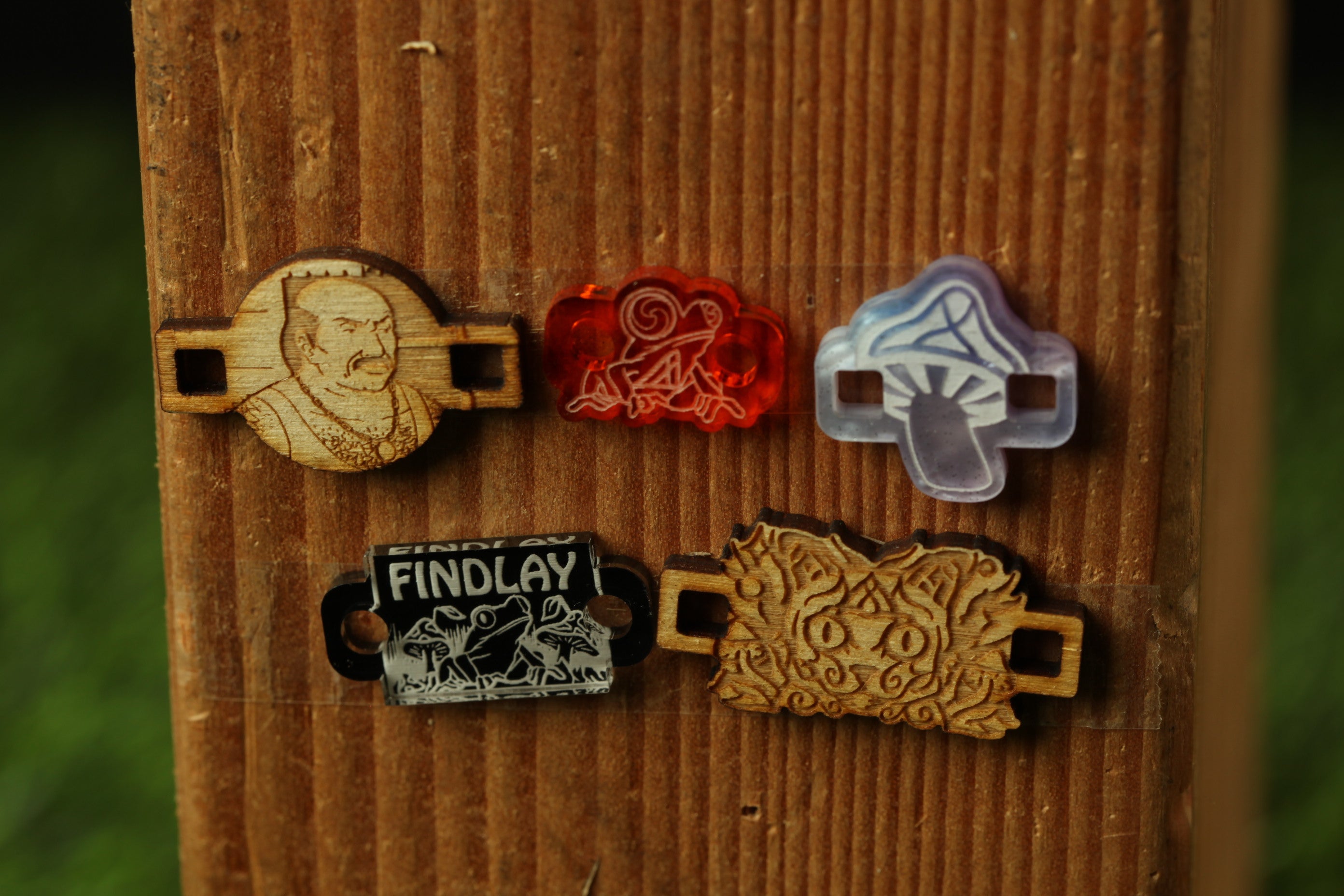 a wooden board with five different wooden pieces attached to it, each with a unique design or symbol.
