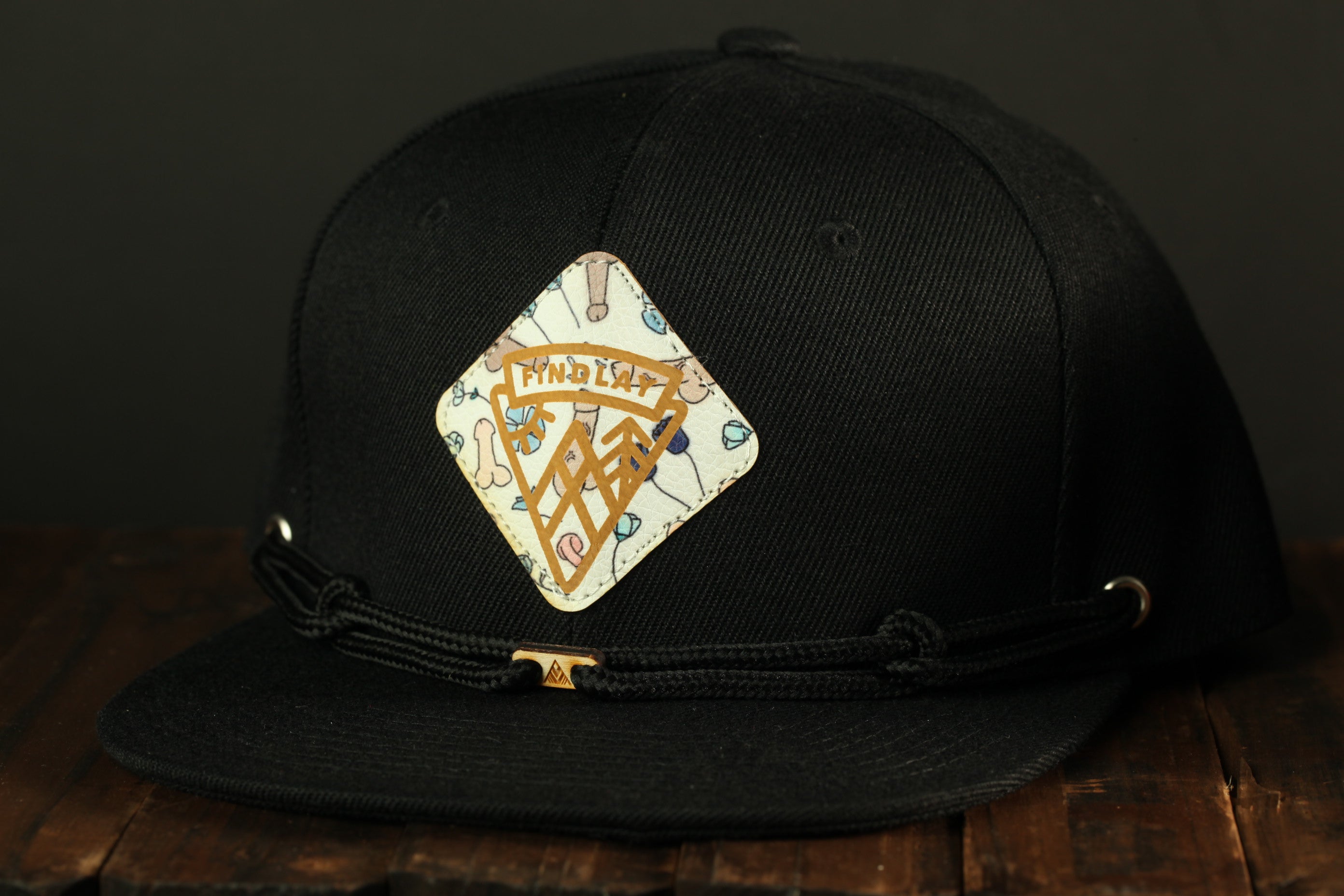 A black baseball cap with a decorative patch on the front.