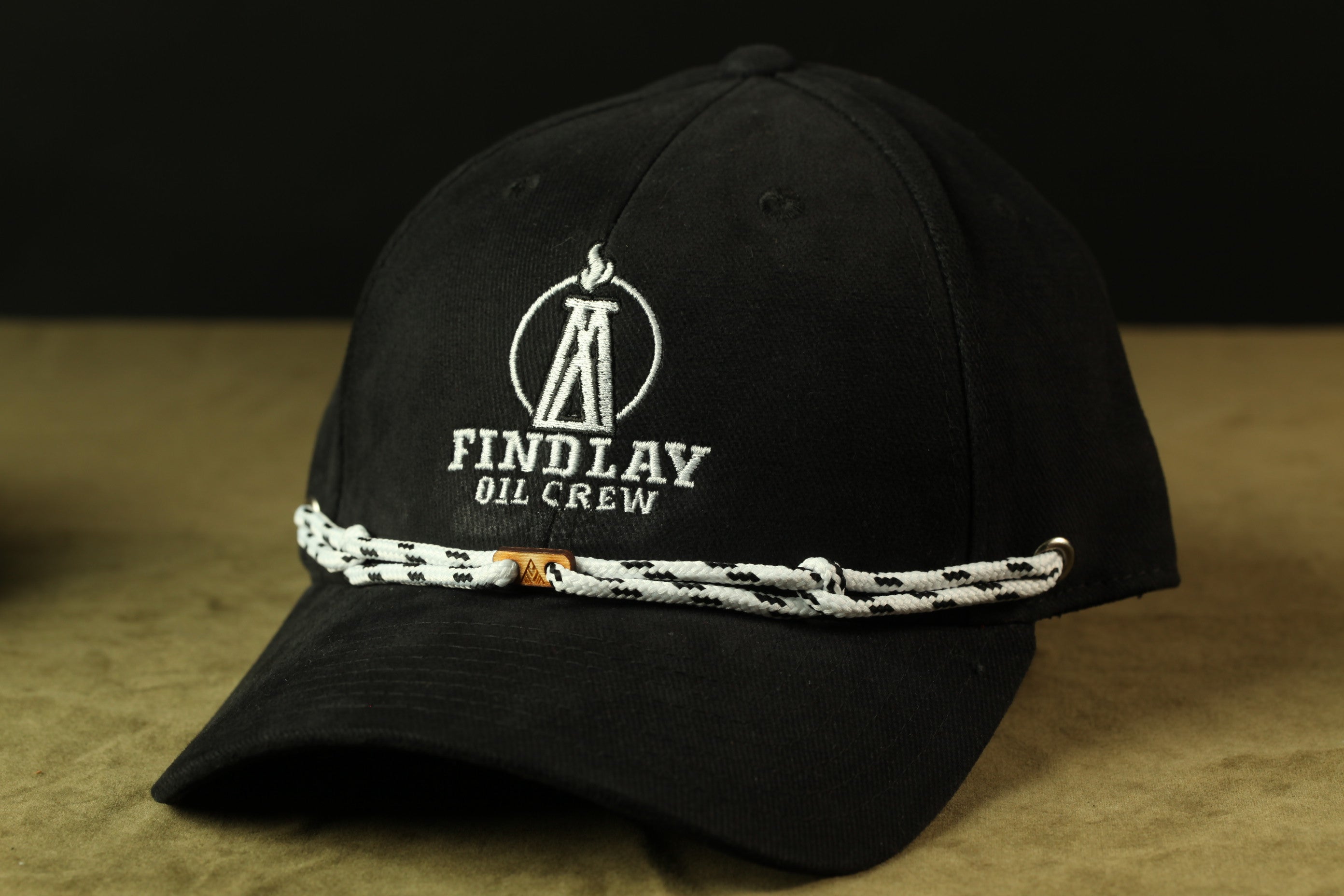 A black baseball cap with a white logo and text on it.