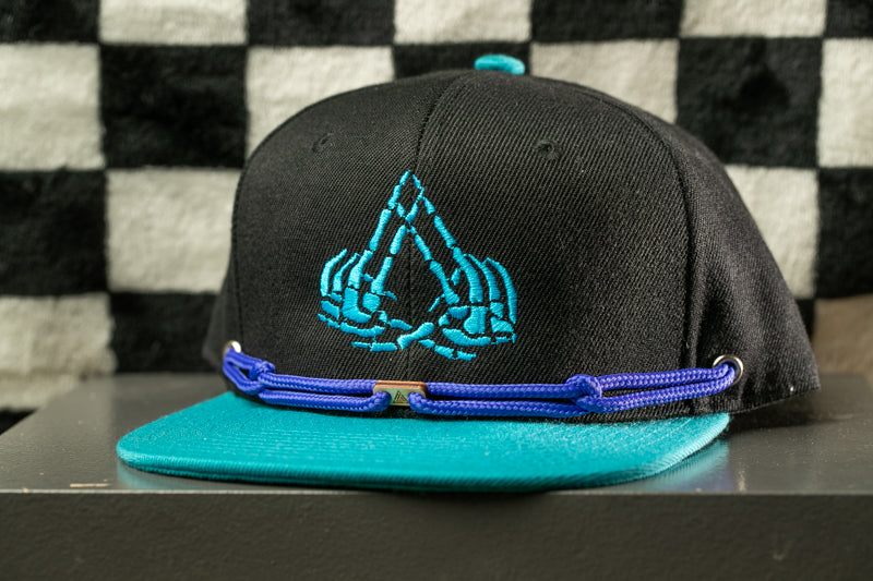 A black baseball cap with a blue and teal trim, featuring a unique embroidered logo on the front.