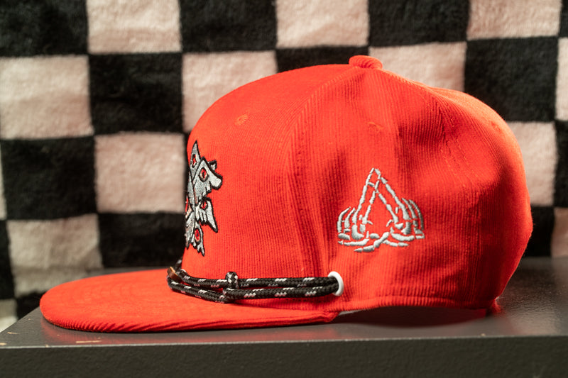 A bright red baseball cap with a black and white checkered pattern on the background.