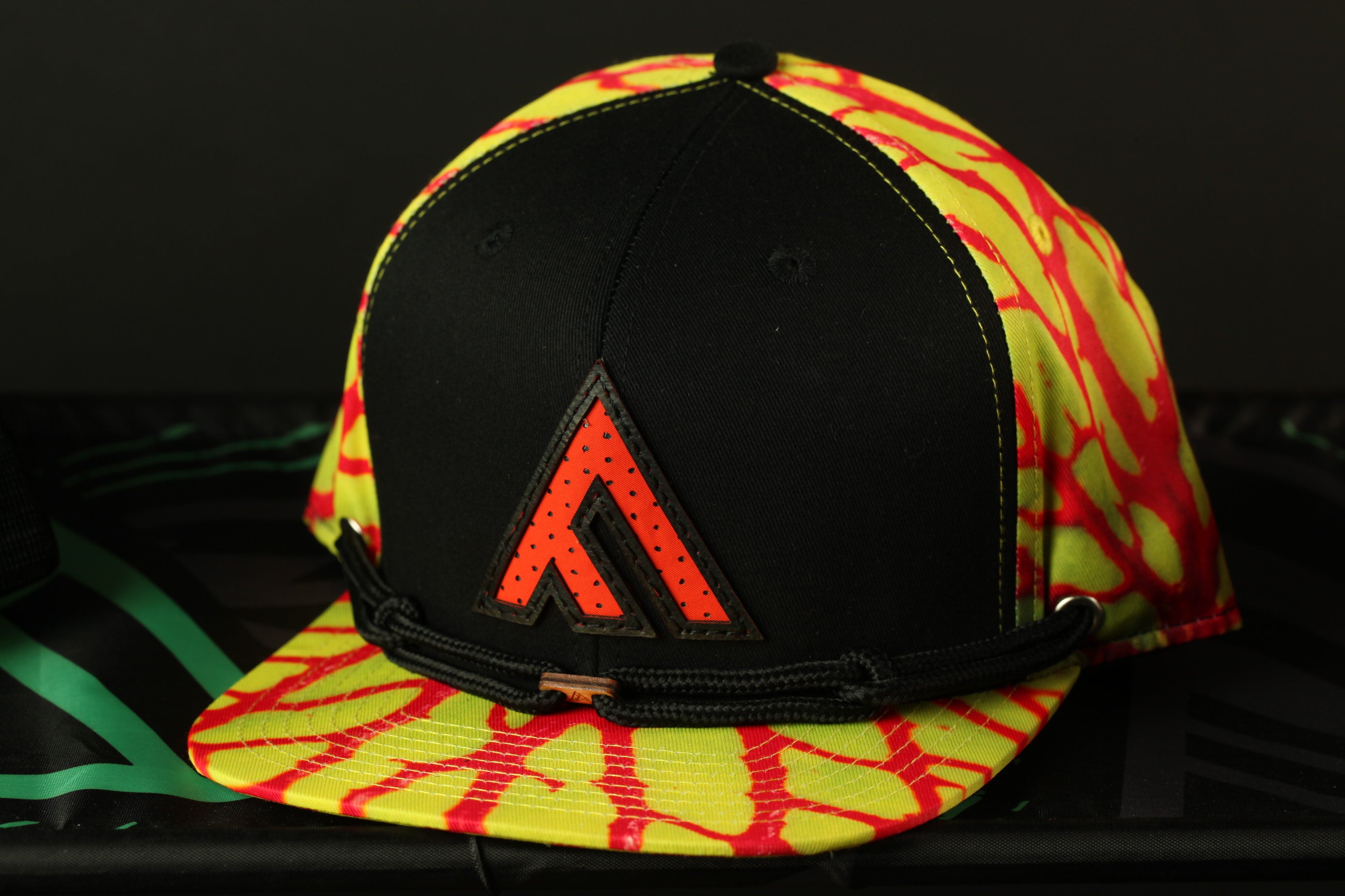 A colorful baseball cap with a black brim and a red and yellow patterned design.