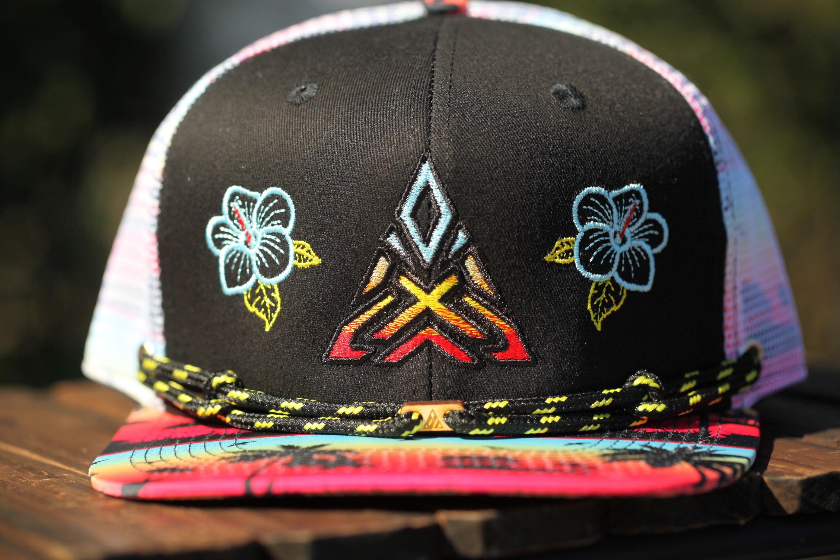 A colorful baseball cap with floral and geometric designs on the front.