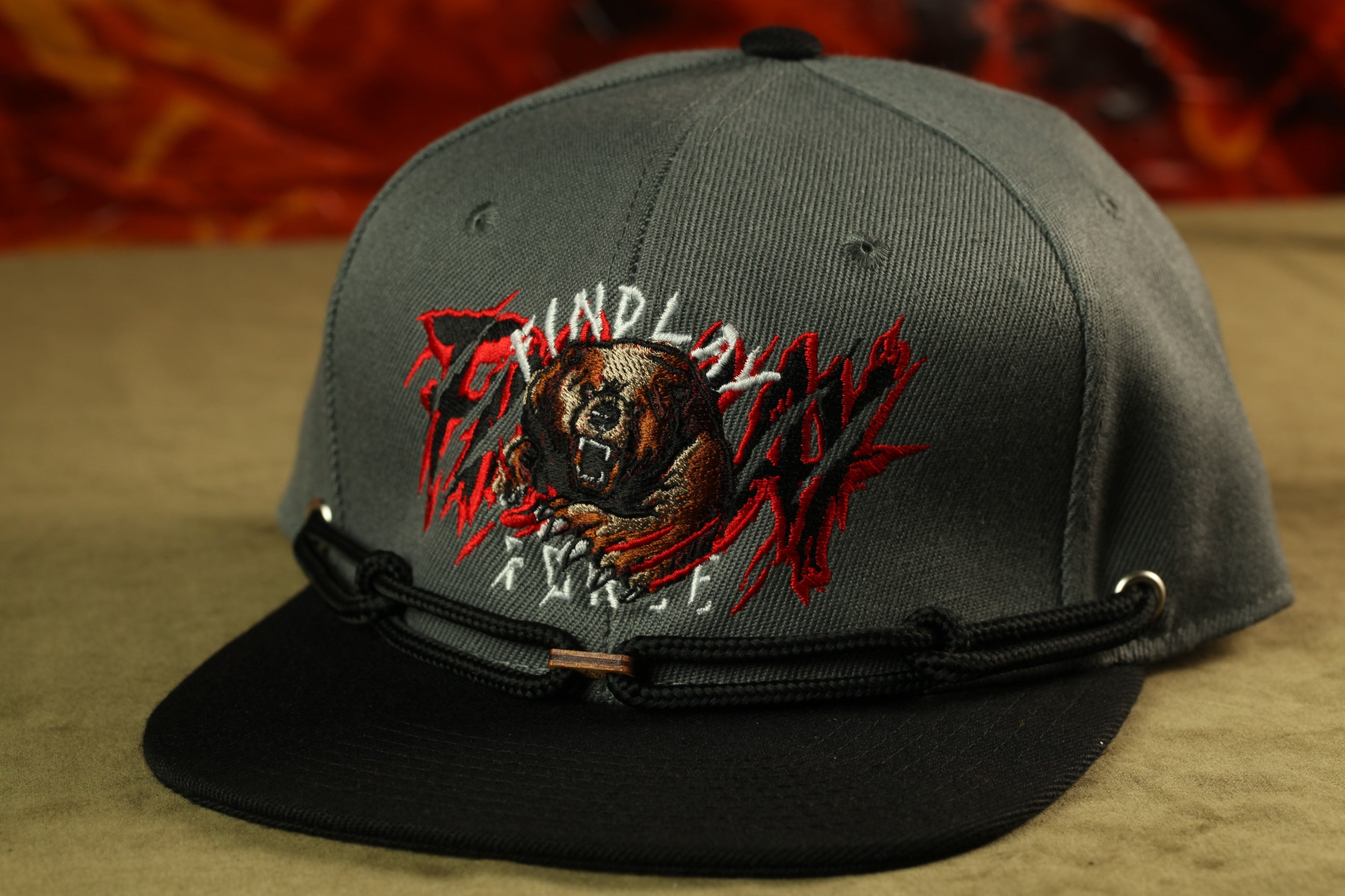 A gray baseball cap with a graphic design featuring a bear and red text.