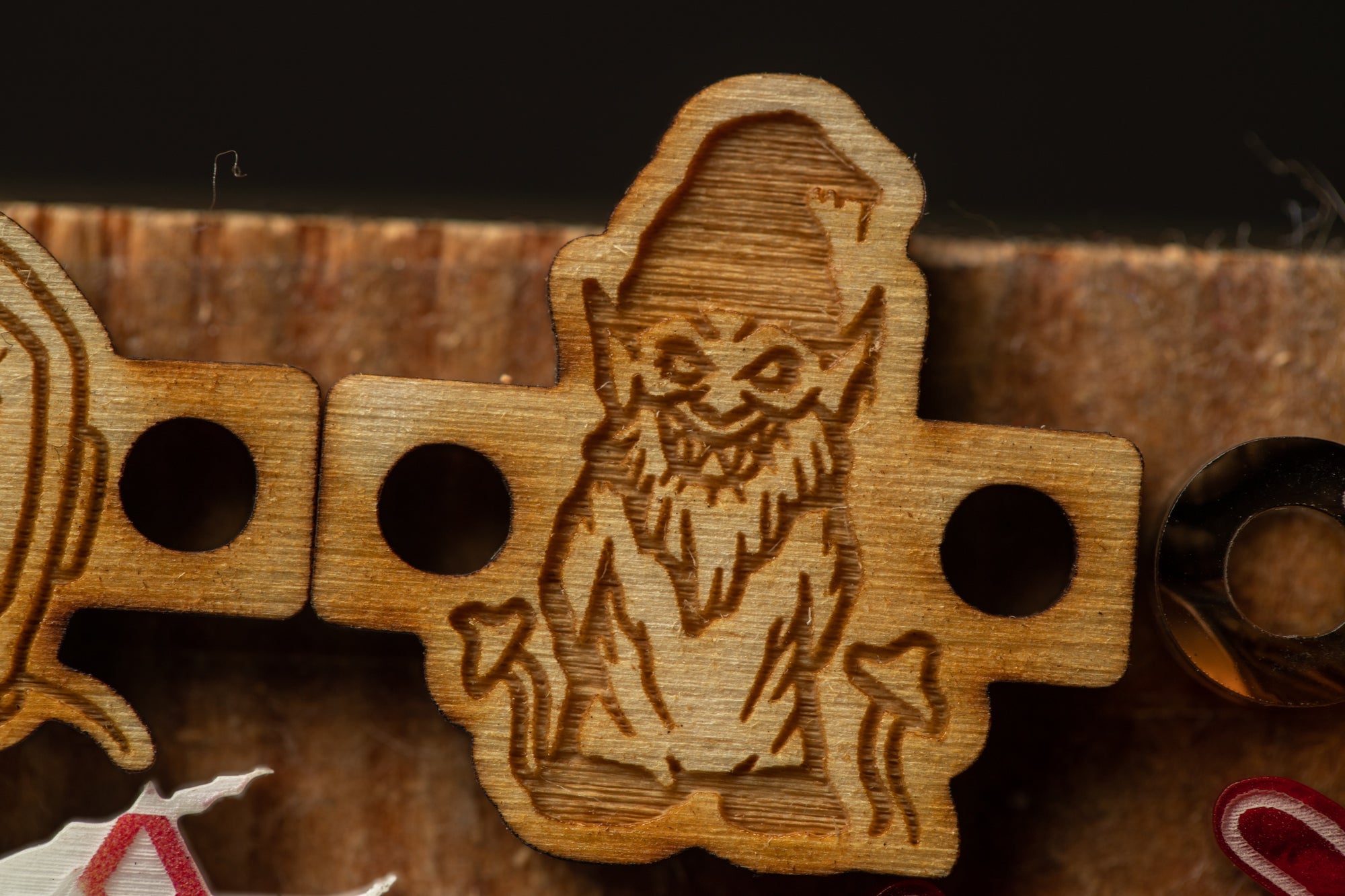 a wooden object with a carved design of a gnome or wizard-like figure.